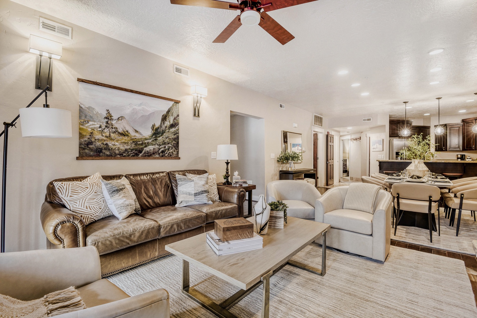 Sink into plush leather seating in your open-concept living space, where a ceiling fan keeps you cool and natural light brightens your relaxing retreat.