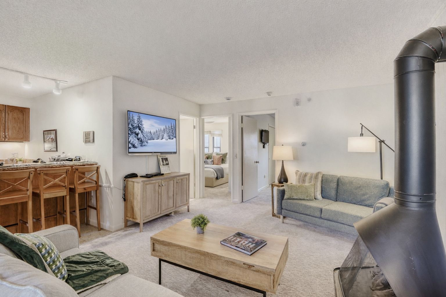 Relax in your open-concept living space featuring a cozy fireplace, modern kitchen, and comfortable seating perfect for unwinding.