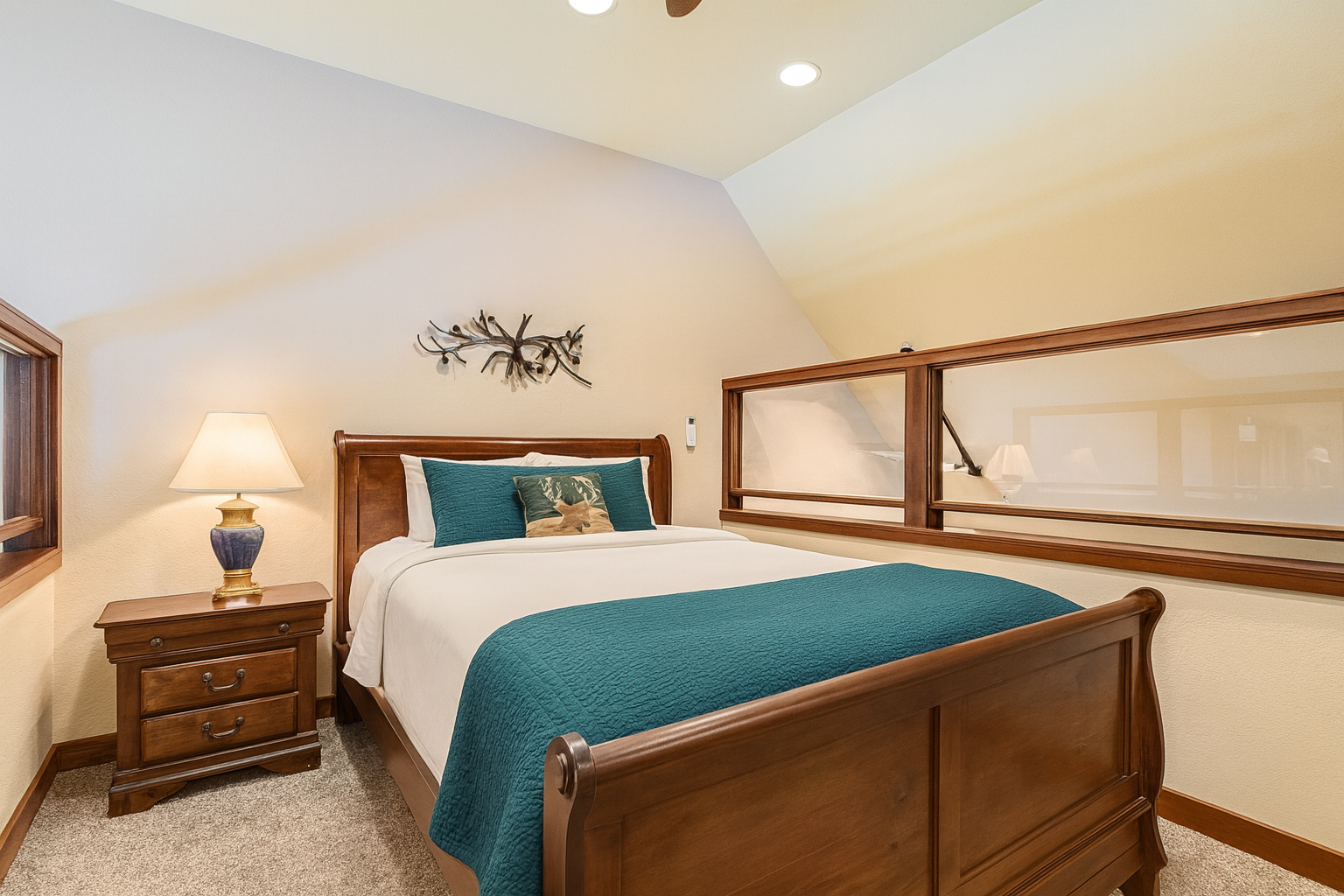 Bright loft bedroom with a comfy queen bed, warm lighting, and rustic wood furnishings. Overlooks the living area and offers a peaceful retreat after exploring Park City. Cozy, inviting, and perfect for a relaxed mountain stay.