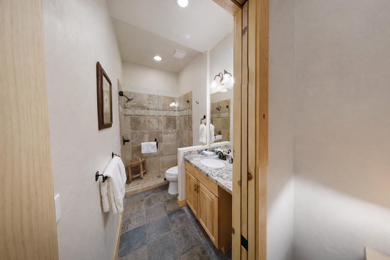 Step into your spa-like bathroom with natural stone tiles, granite countertops, and a spacious walk-in shower perfect for unwinding.