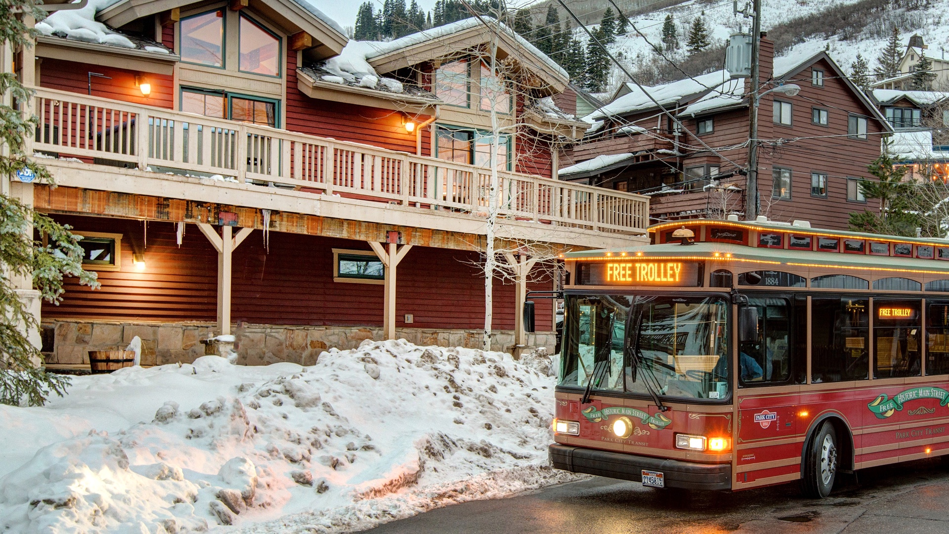 A charming mountain lodge with snow-covered balconies and warm lighting creates the perfect alpine retreat setting.