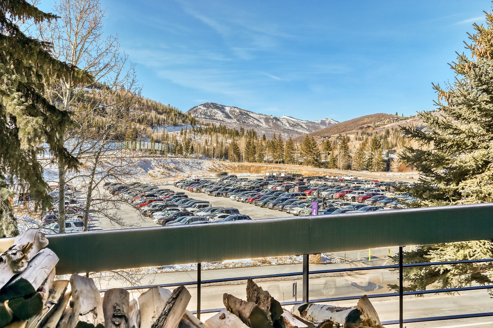 Spacious parking area with stunning mountain views and winter scenery surrounds the property.