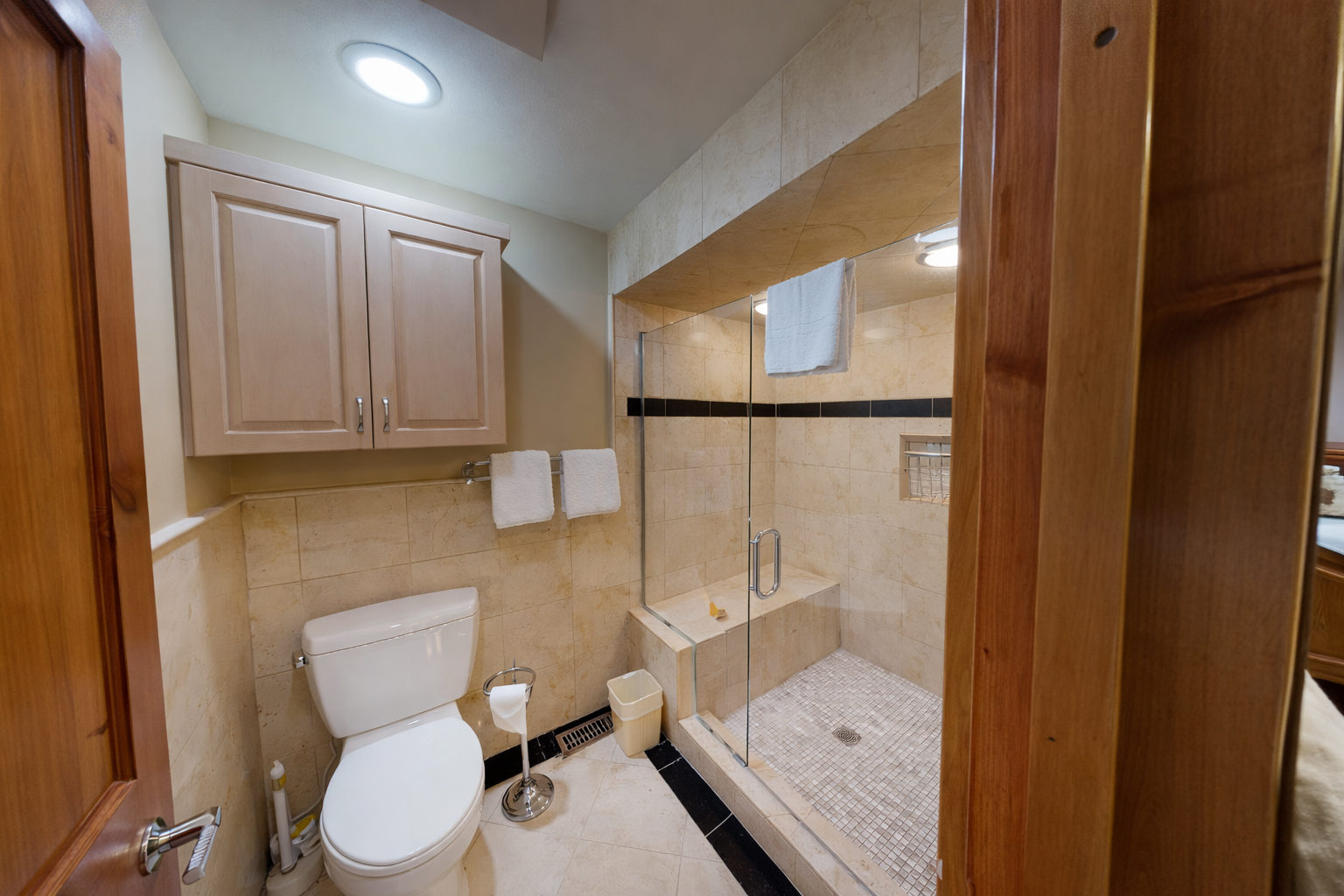Relax in this modern bathroom featuring a walk-in glass shower, a sleek vanity, and clean tile finishes. It's the perfect spot to refresh after a day outdoors.