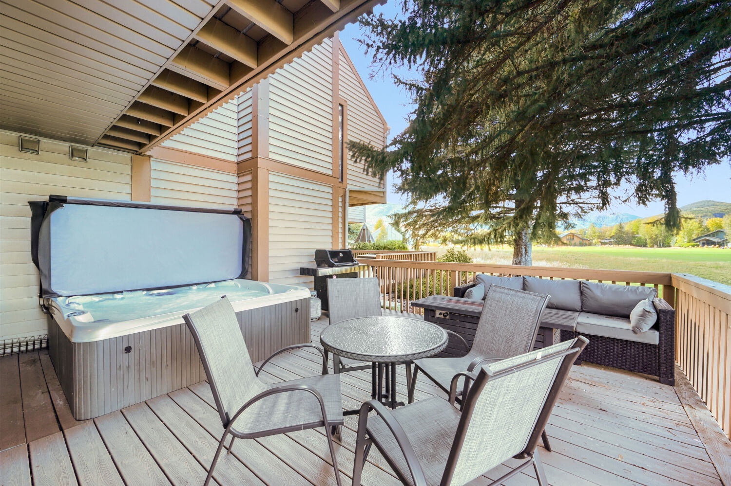 This private deck is your mountain retreat. Sink into the hot tub, gather around the table, or stretch out on the outdoor sofa while taking in open views of surrounding natural landscape.