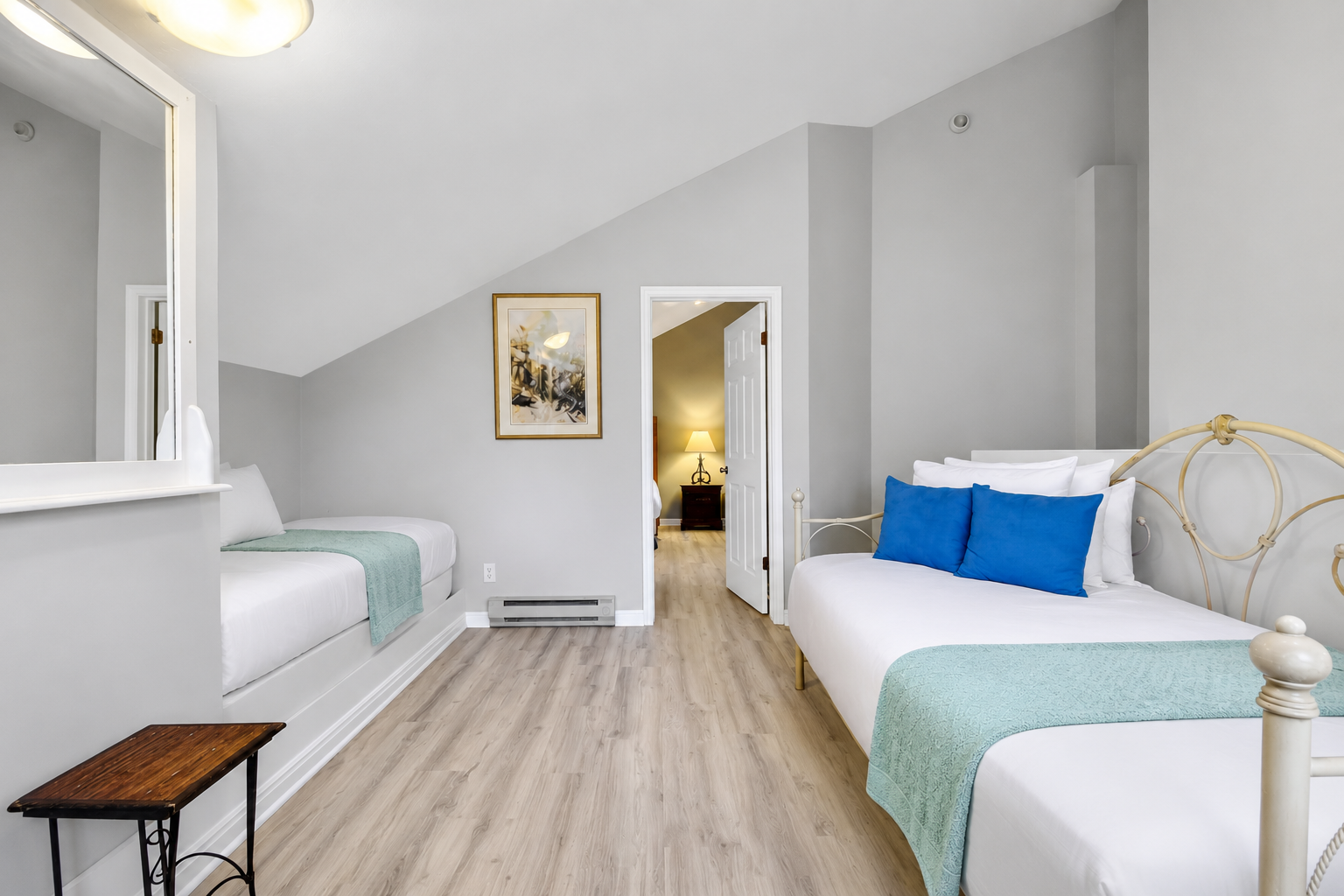 Unwind in your spacious bedroom with two inviting beds dressed in crisp linens and pops of blue. Vaulted ceilings, warm lighting, and thoughtful decor create a peaceful retreat after your adventures.