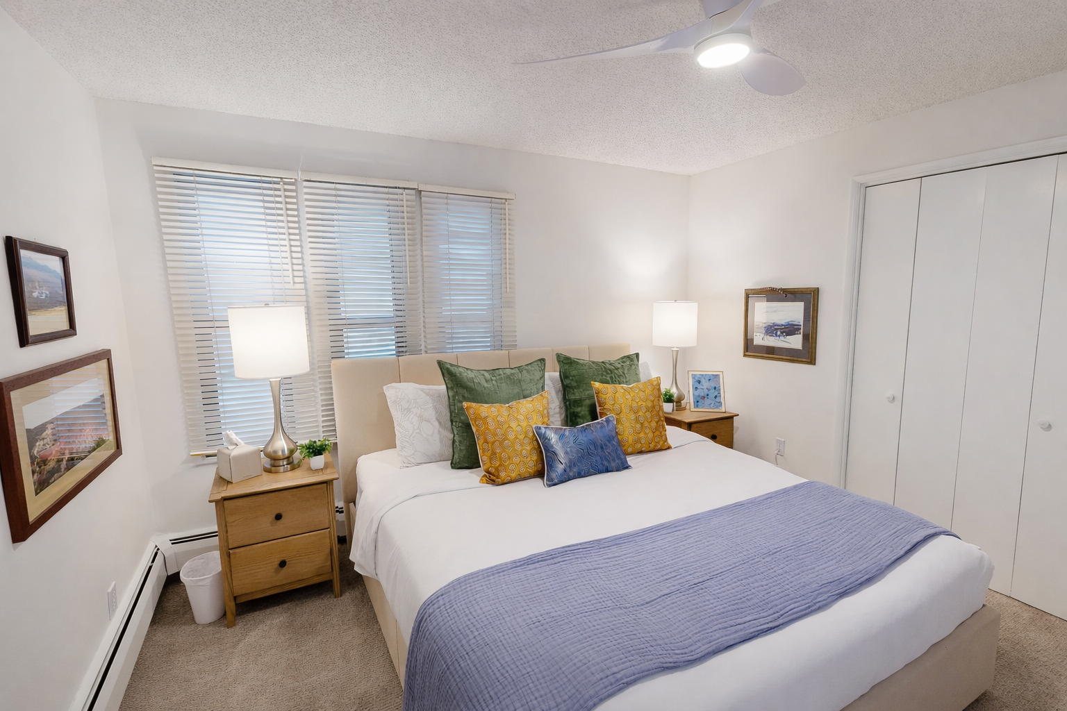 Sink into crisp white linens with vibrant accent pillows in your peaceful bedroom retreat, complete with thoughtful bedside lighting and ample storage.