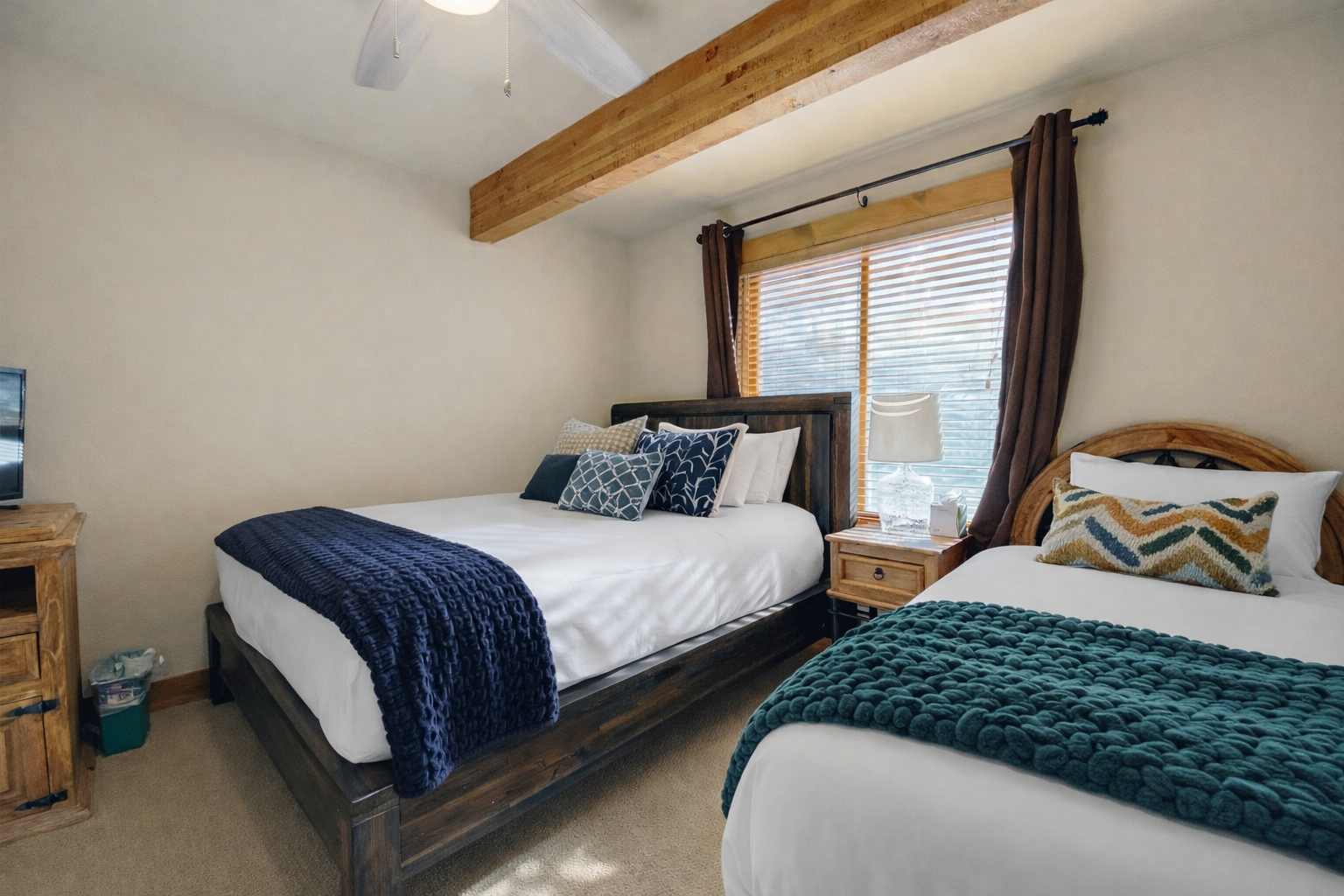 Relax in your cozy twin bedroom with rustic wood beams, crisp linens, and gentle natural light filtering through.