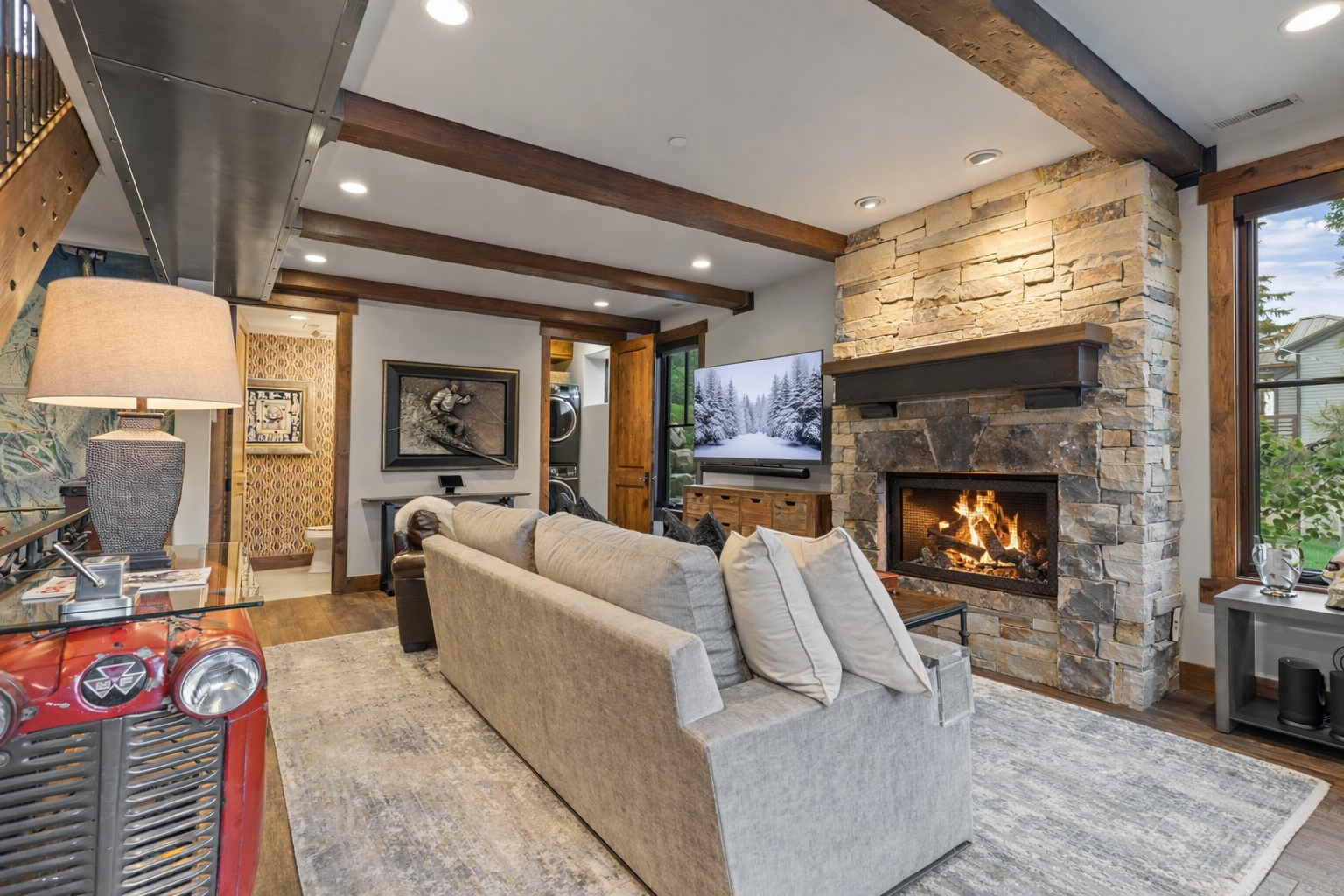 Unwind in the cozy living area with a stunning stone fireplace, large sofa, and smart TV.
