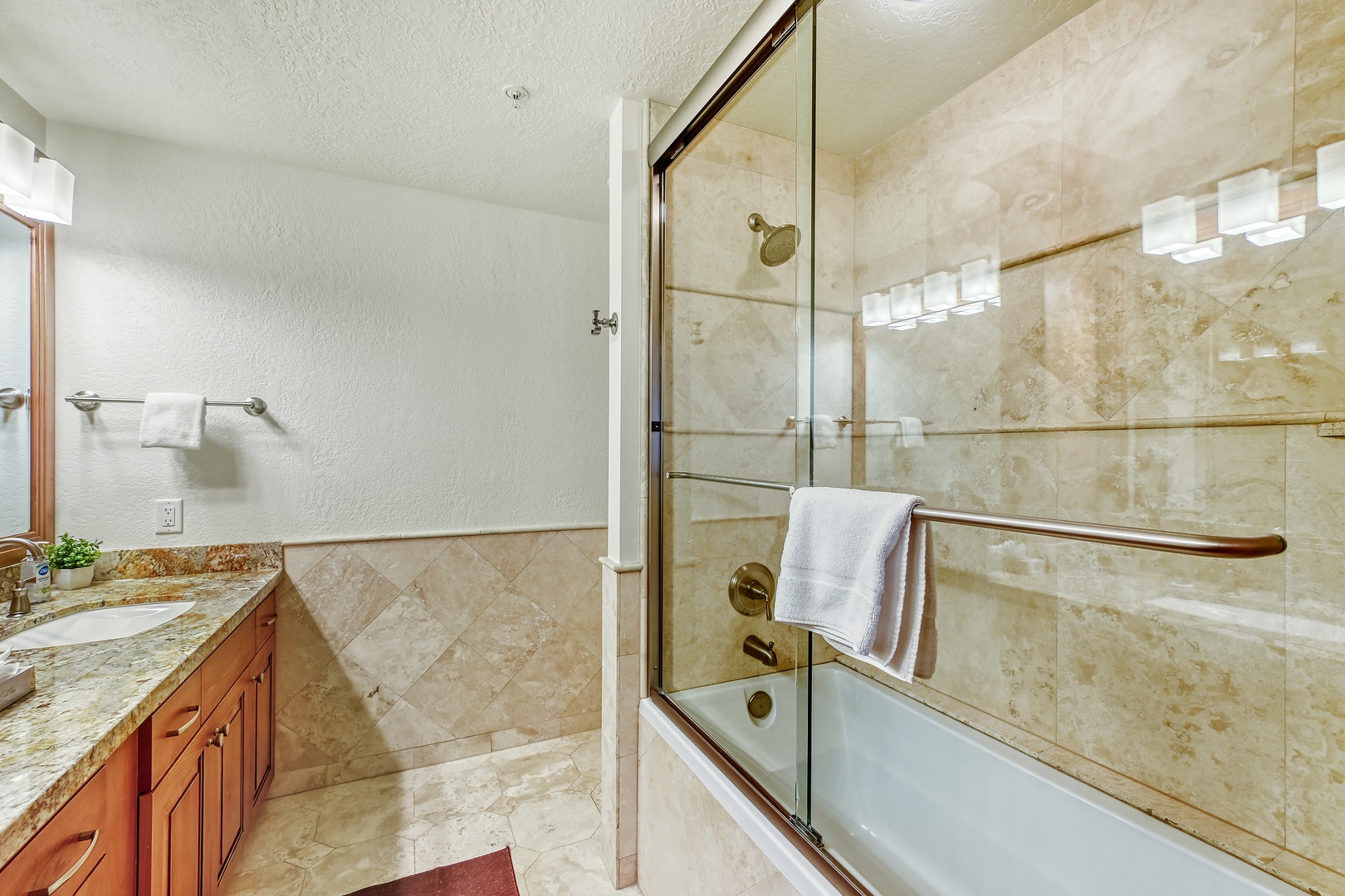 Unwind in your luxurious marble bathroom featuring elegant travertine tile, spacious glass shower, and soaking tub for ultimate relaxation.