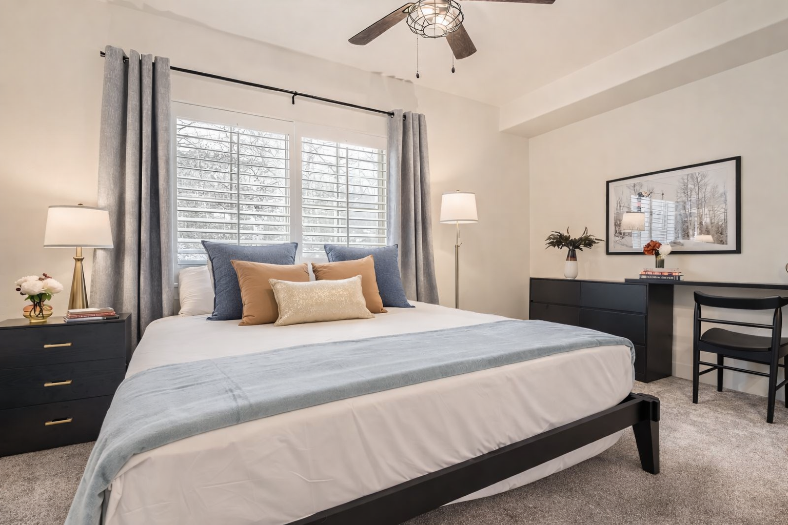 Relax in this bright, modern bedroom featuring a plush king-size bed, sleek dark wood furniture, and a large flat-screen TV. A serene mountain retreat for your next Park City adventure.
