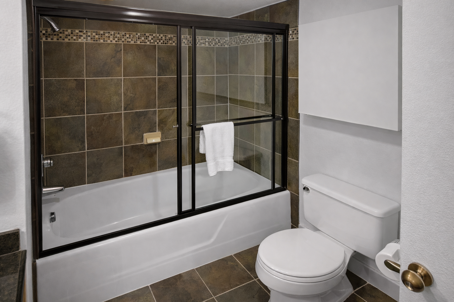 Unwind in your private bathroom with a sleek tub-shower combo, elegant tile work, and fresh towels ready for you to enjoy.