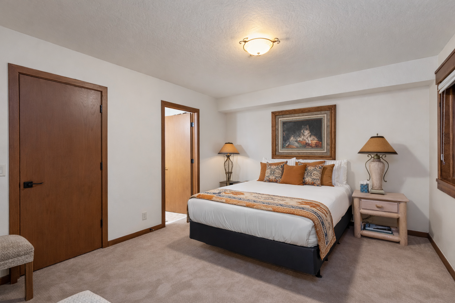 Sink into crisp linens and plush pillows in your tranquil bedroom retreat, where elegant artwork and warm lighting create the perfect atmosphere for restful nights.