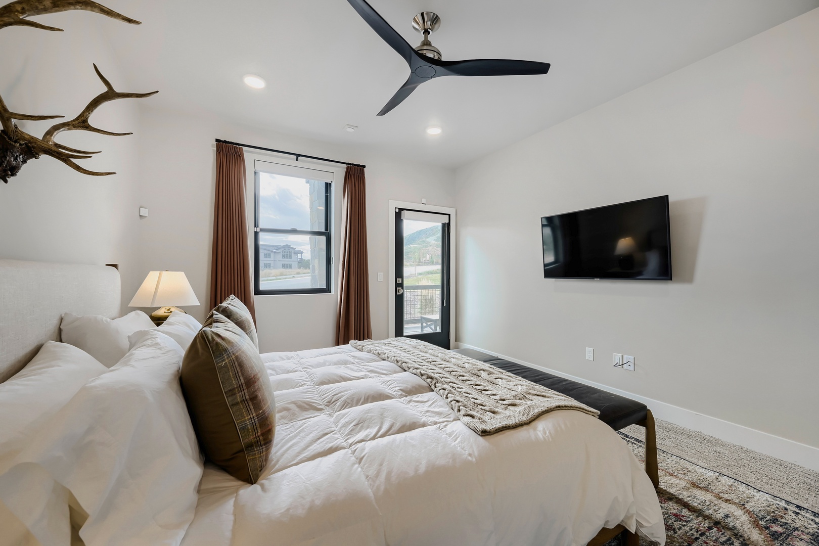 Wake up in this peaceful retreat where rustic charm meets modern comfort. Your room features a plush bed with cozy linens, a private balcony, and stunning mountain views just beyond the glass door—perfect for unwinding after a day exploring.