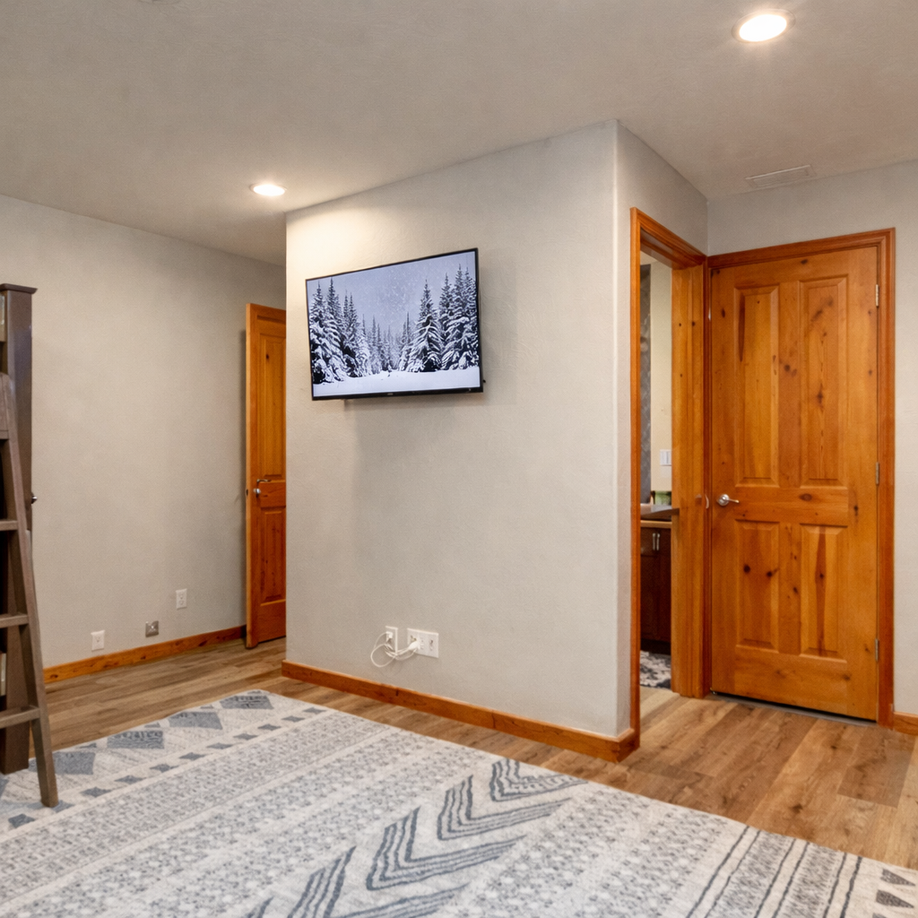 Enjoy our fun bottom level bunkroom featuring two sets of L-shaped bunks with cozy bedding. An ideal space for kids or extra guests to relax during your mountain getaway.