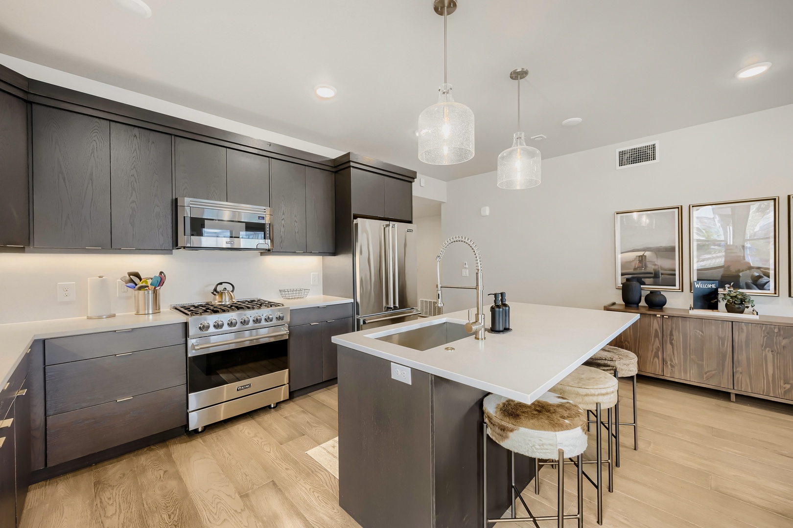 Your gourmet kitchen features sleek dark cabinetry, gleaming stainless steel appliances, and a stylish island with bar seating—perfect for preparing meals and gathering with friends or family.