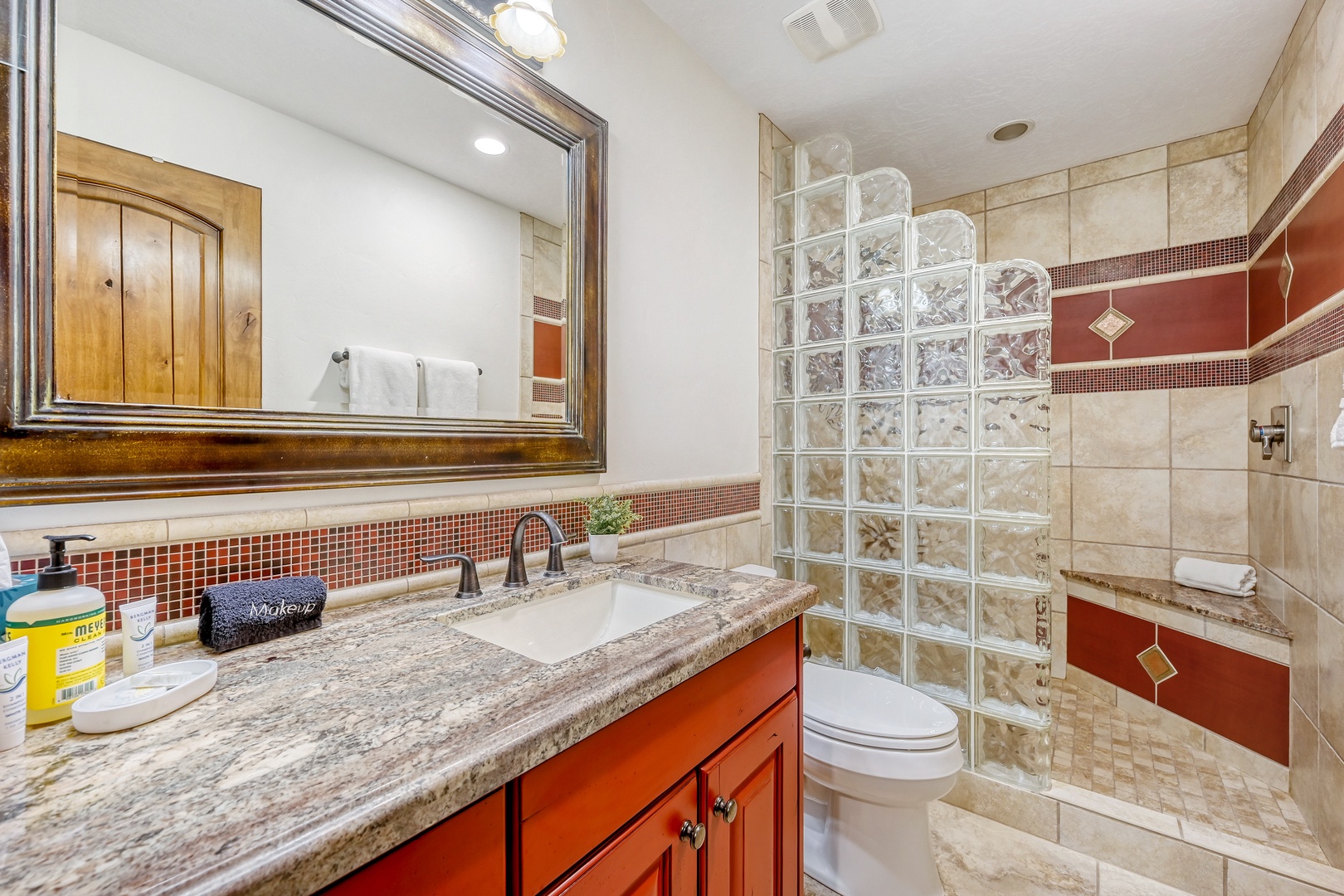 Your private bathroom features rich tile work, granite counters, and a spacious glass-block shower for refreshing mornings.