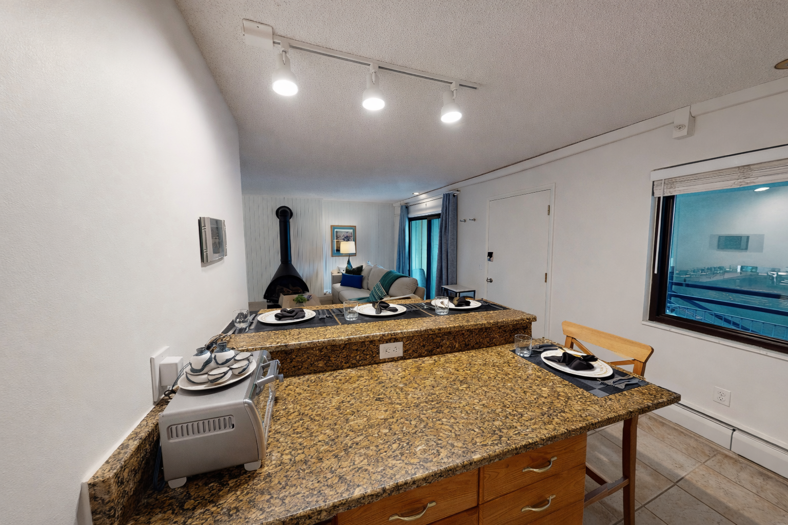 Your open kitchen features granite counters and modern track lighting, creating the perfect space to prepare meals while staying connected to your living area.
