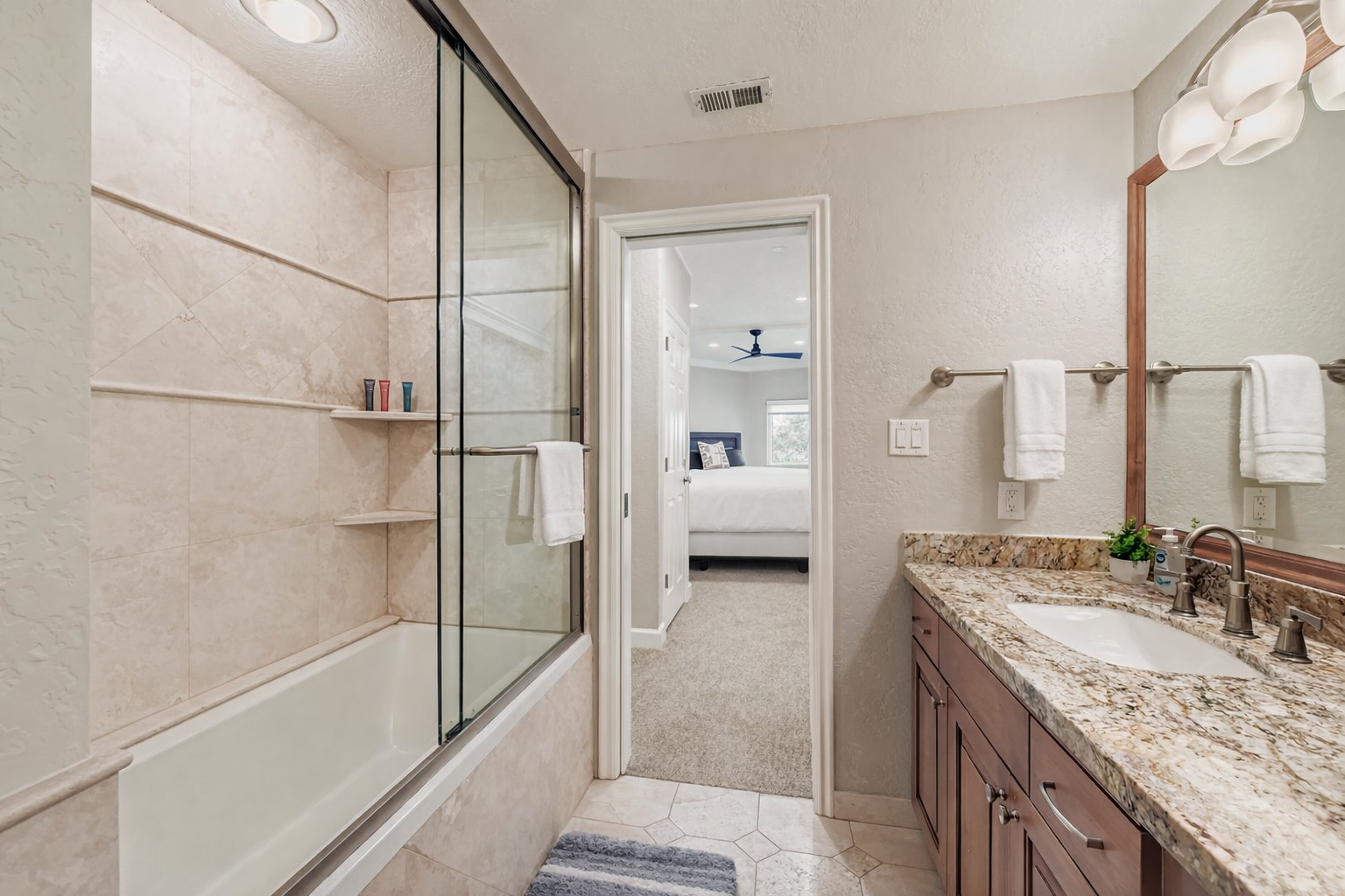 Your private bathroom features granite countertops, dual sinks, and a spacious shower with glass doors, creating a luxurious retreat for your daily routine.