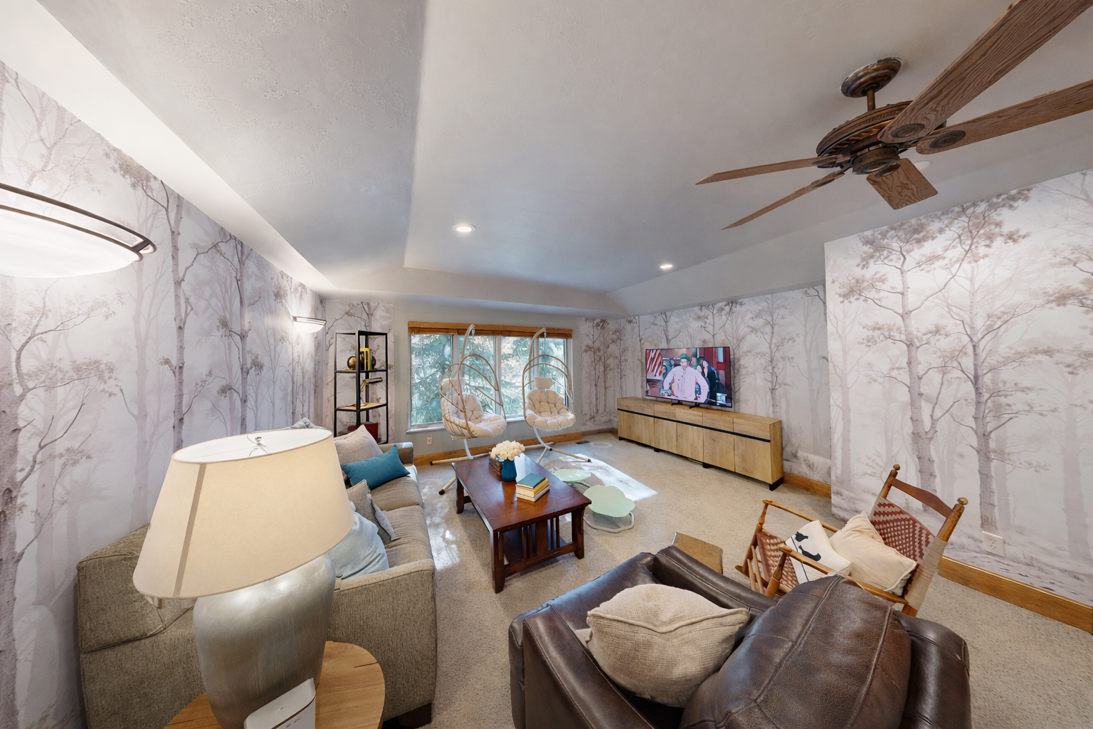 Unwind in your elegant living space with serene forest wallpaper, plush seating, and modern entertainment setup creating the perfect retreat.