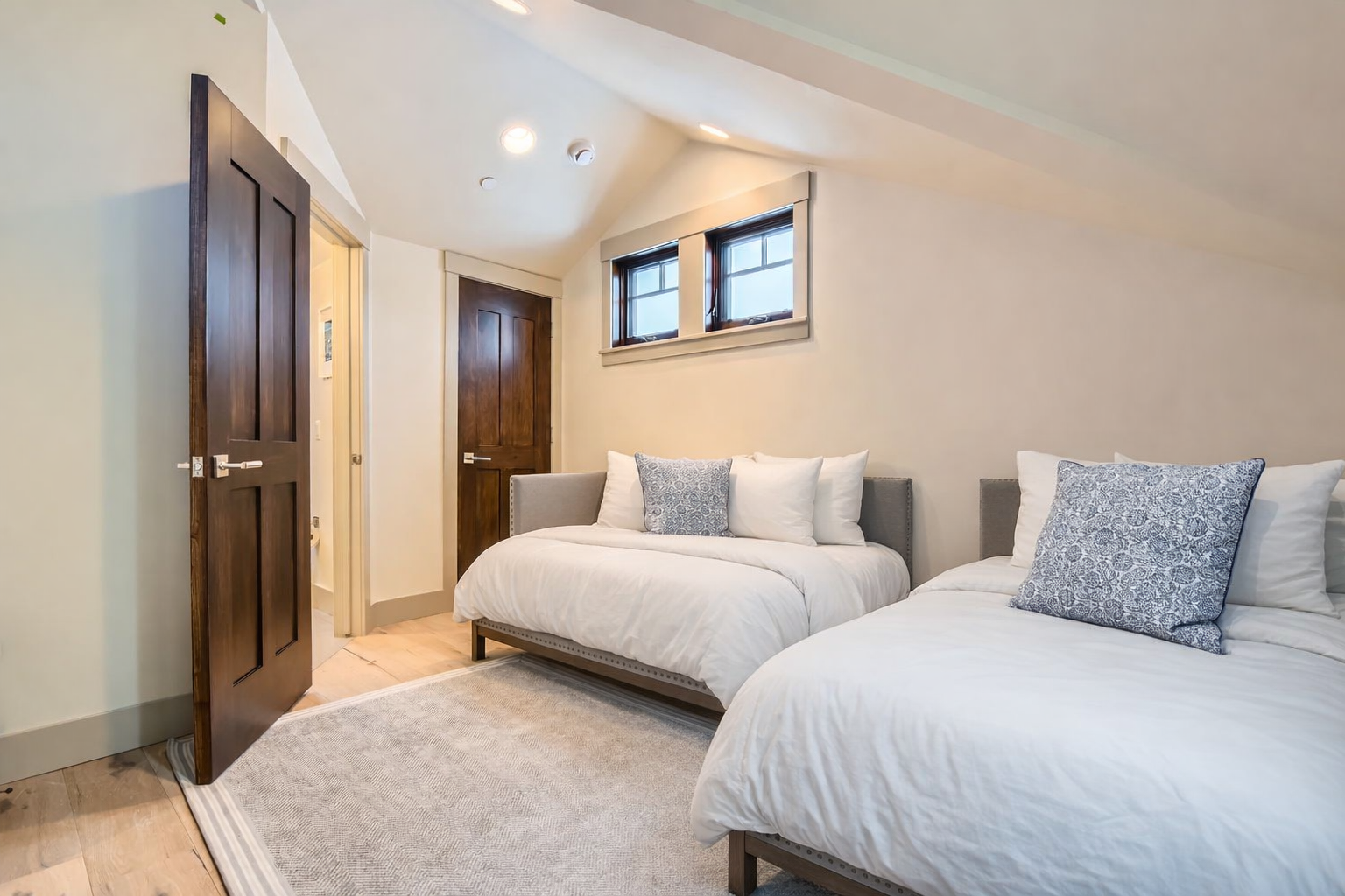 Retreat to this charming room featuring two comfortable twin beds with soft linens and cozy pillows, all beneath a beautiful vaulted ceiling. A restful space for your Park City getaway.