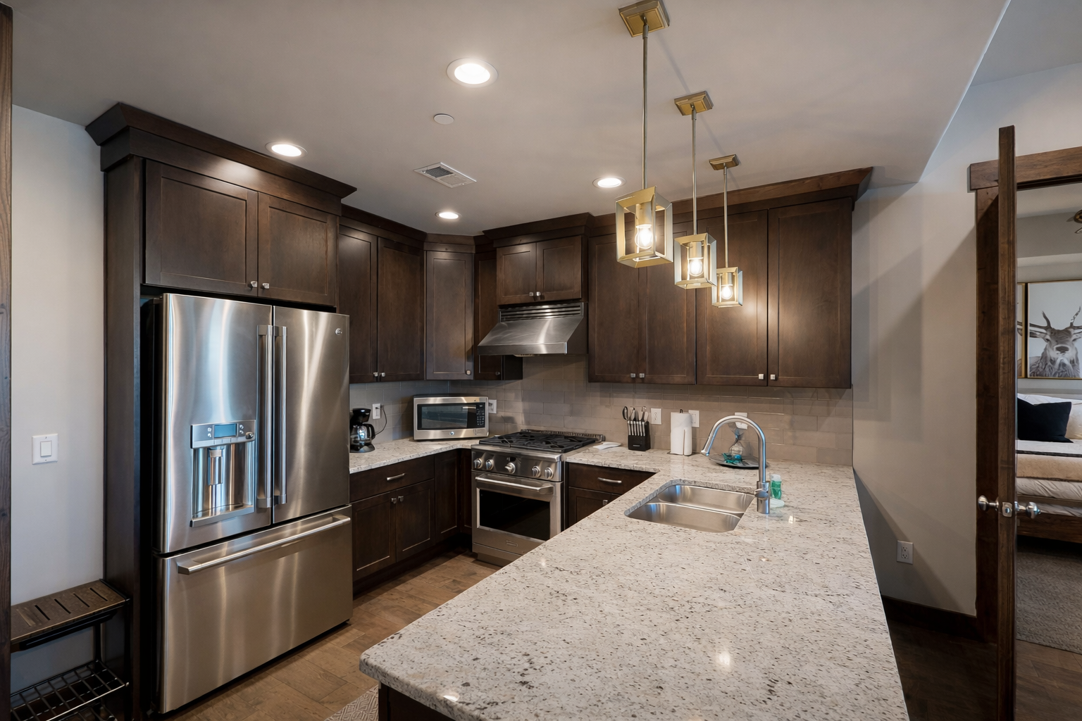 Prepare meals in a fully equipped chef's kitchen featuring high-end Viking stainless steel appliances, sleek quartz countertops, and a large island with seating for four.