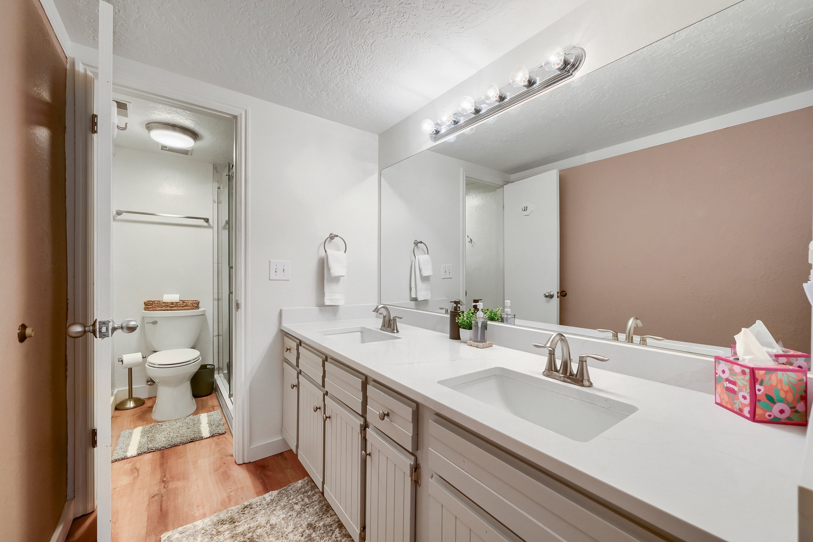 Freshen up in your well-lit dual-sink bathroom, offering plenty of counter space and a clean, welcoming design for your daily routine.