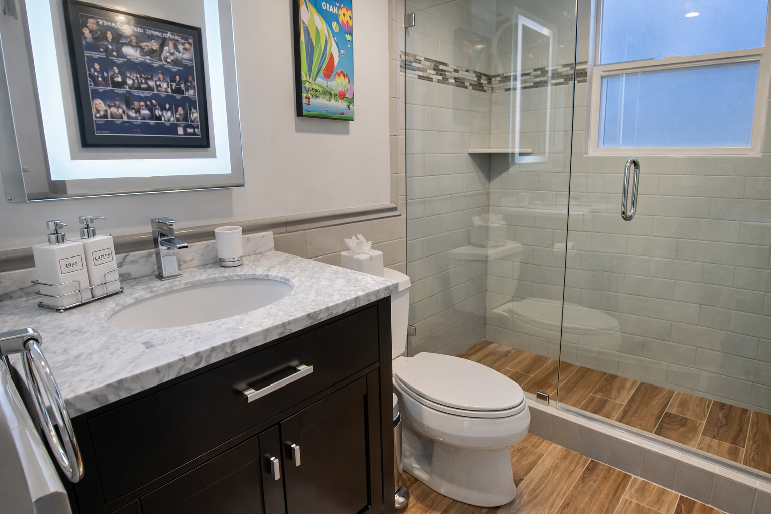 Step into this sleek, modern bathroom with a spacious walk-in shower and wood-look flooring.