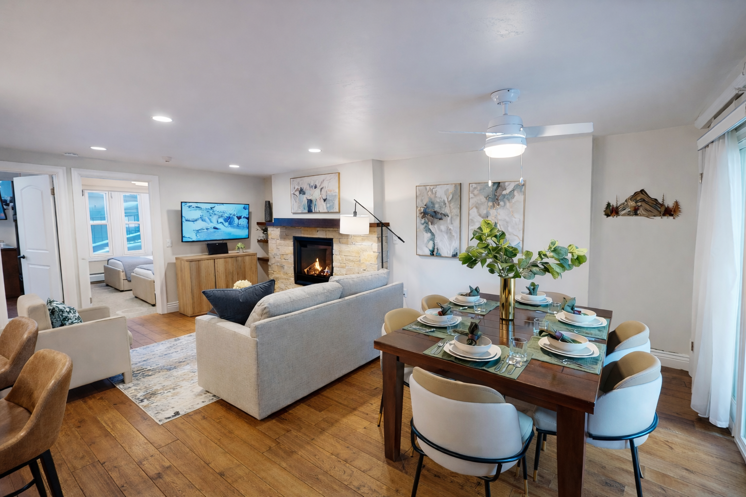 Relax in your spacious living room featuring a cozy stone fireplace, comfortable sectional seating, and modern decor that creates the perfect atmosphere for unwinding.