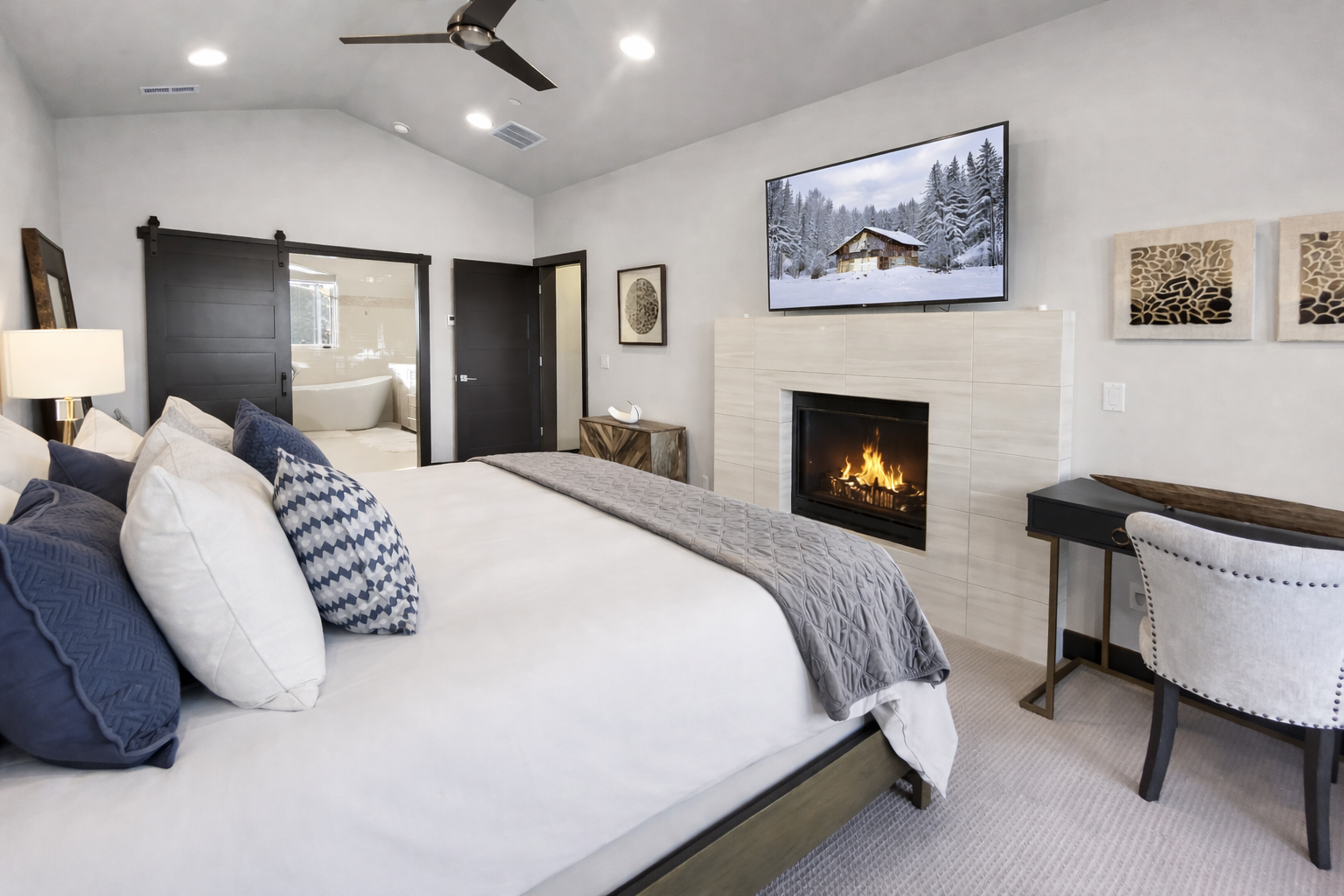 Unwind in your luxurious bedroom with a crackling fireplace, plush bedding, and a cozy seating area perfect for relaxing evenings.