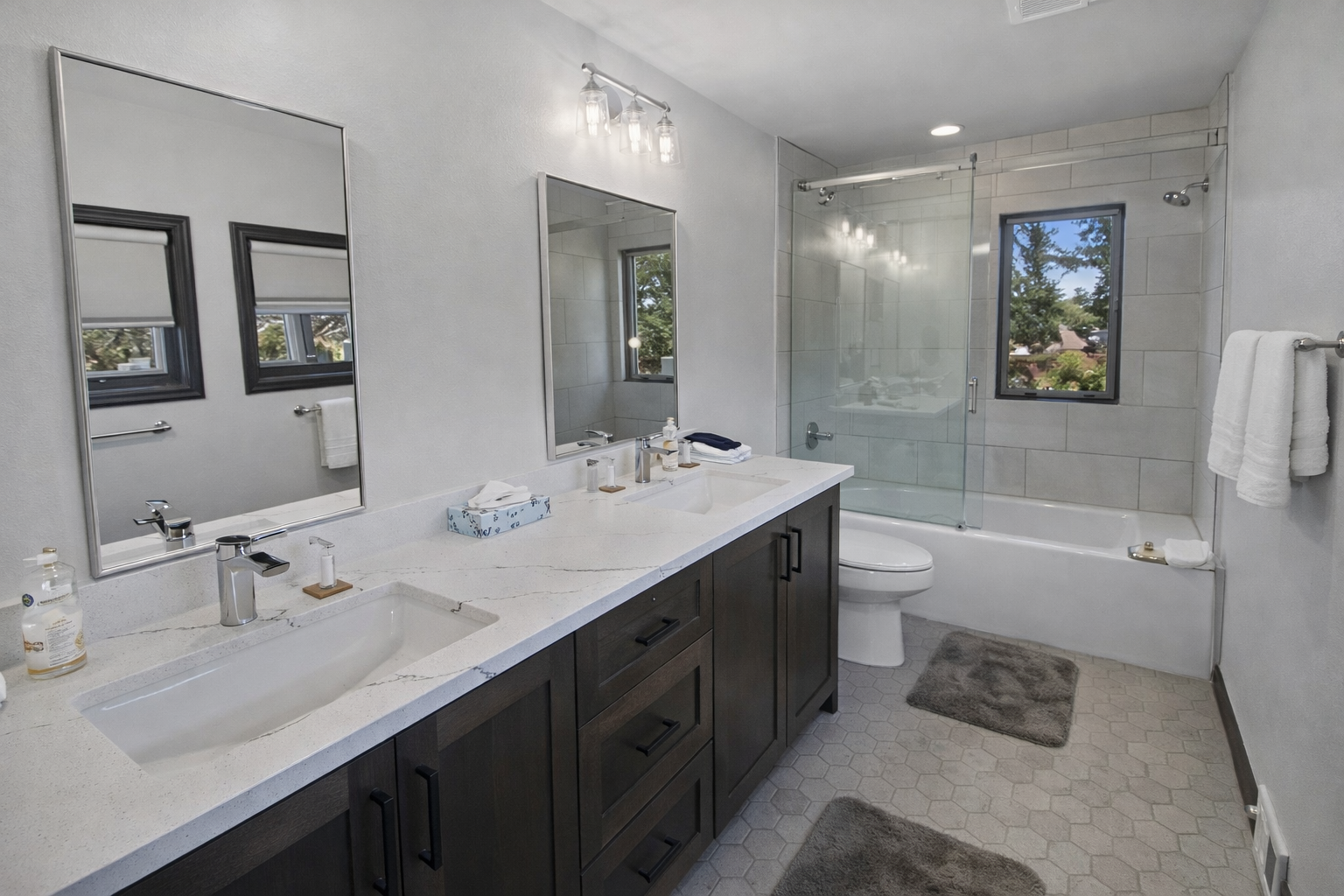Spacious modern bathroom with a large double vanity and a convenient tub/shower combo. Sparkling clean and bright for a refreshing start to your day.