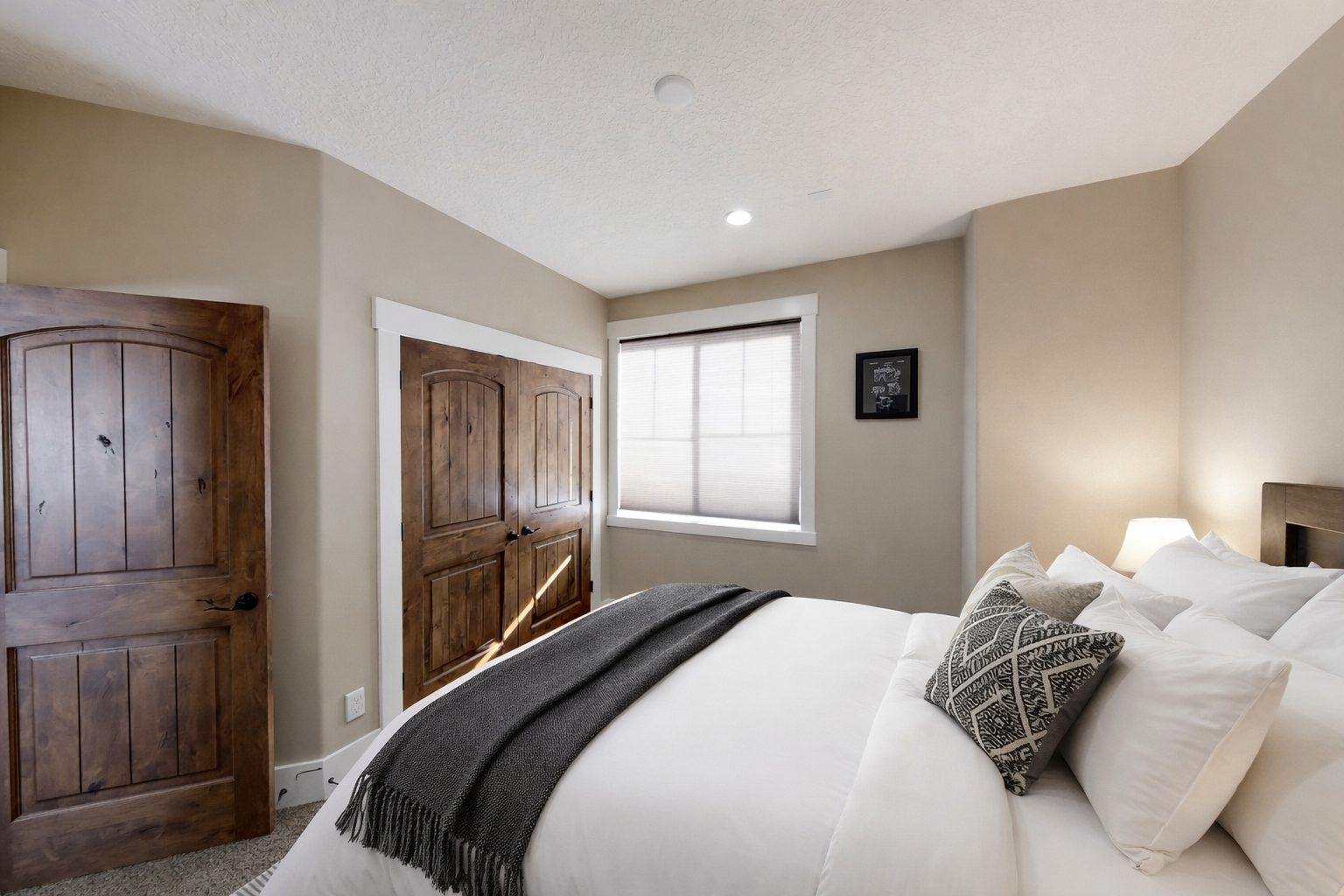 Unwind in your cozy bedroom with rustic wooden doors, soft linens, and gentle natural light streaming through your window.