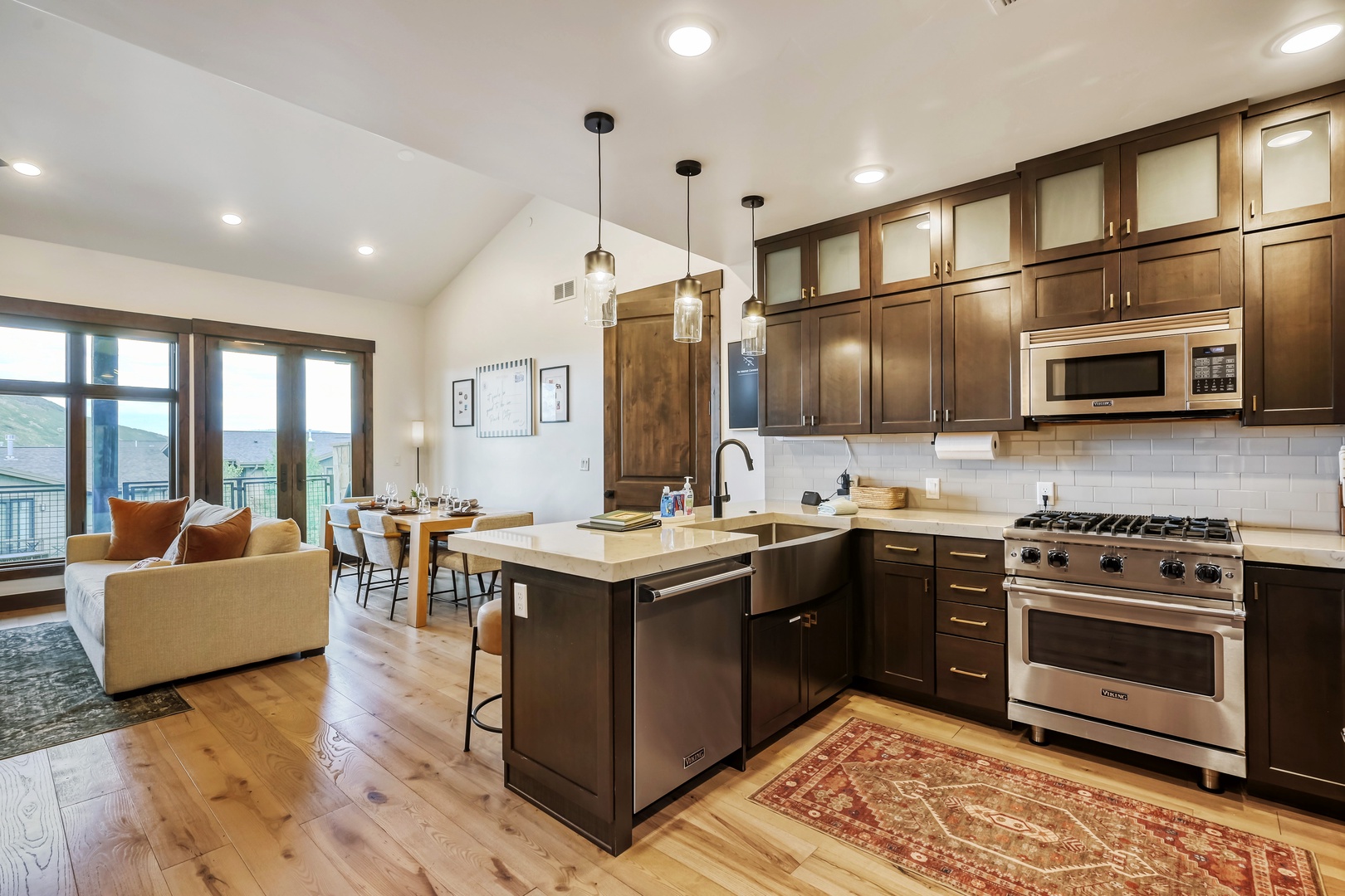 Step into your open-concept retreat with a fully-equipped gourmet kitchen, elegant wood cabinetry, and a spacious island perfect for morning coffee or meal prep.