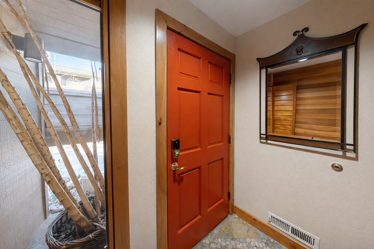 A welcoming red door opens to your mountain retreat, where warm wood details and rustic touches create the perfect arrival experience.