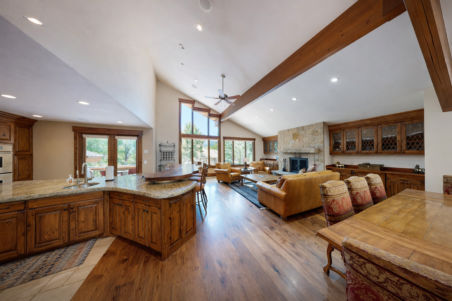 Relax in our spacious living area with a vaulted wood ceiling, cozy fireplace, and stunning views of the surrounding nature.