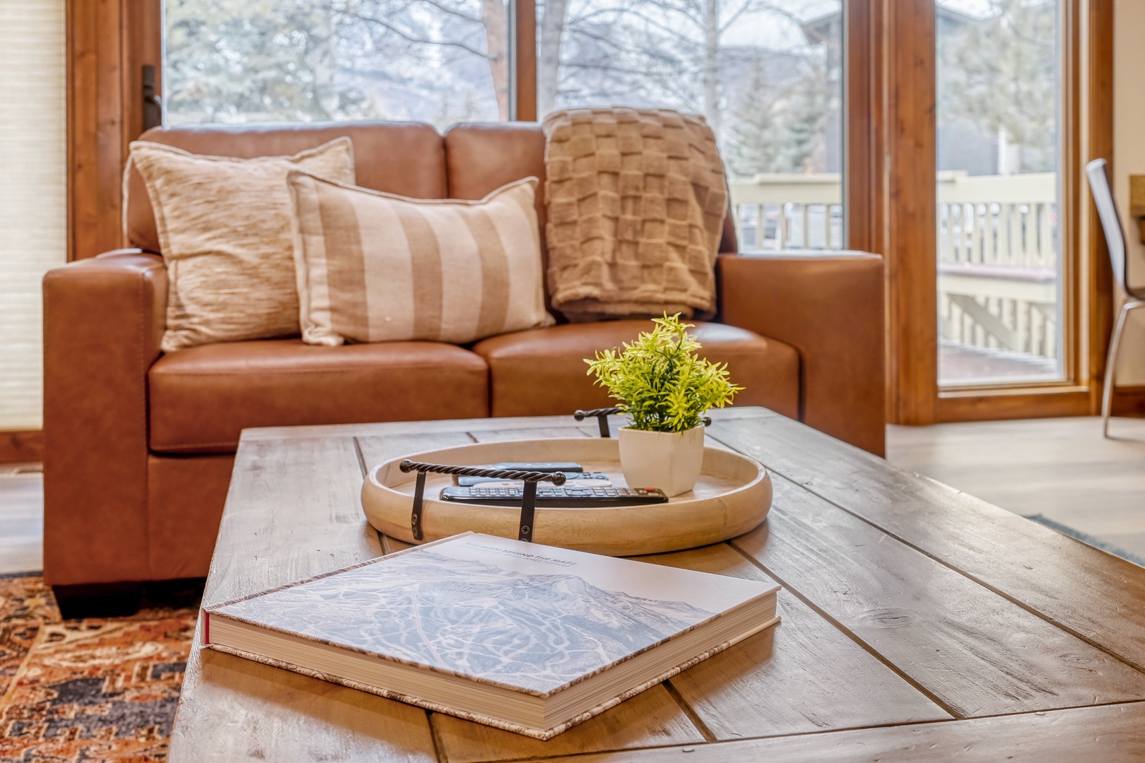 Sink into this cozy leather sofa where you'll unwind with afternoon light streaming through windows onto warm wood floors.