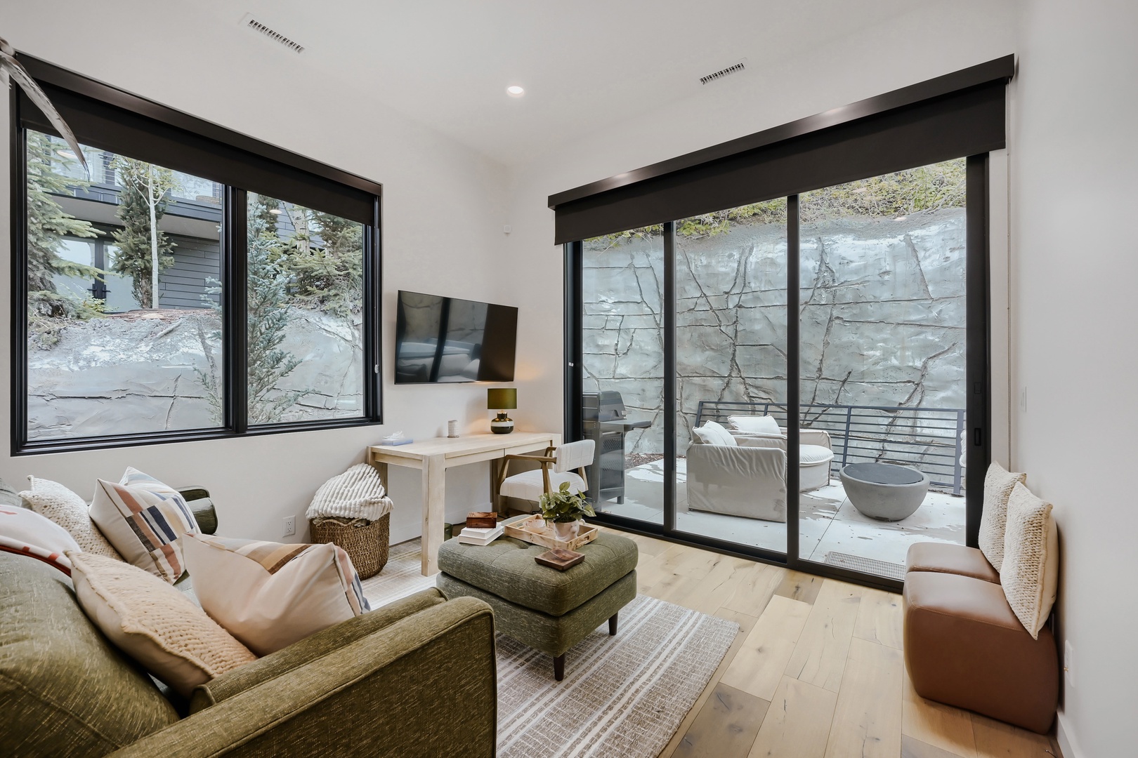 Bright, modern living space with floor-to-ceiling windows overlooking a serene courtyard. Private patio via glass doors—ideal for morning coffee or relaxing evenings.