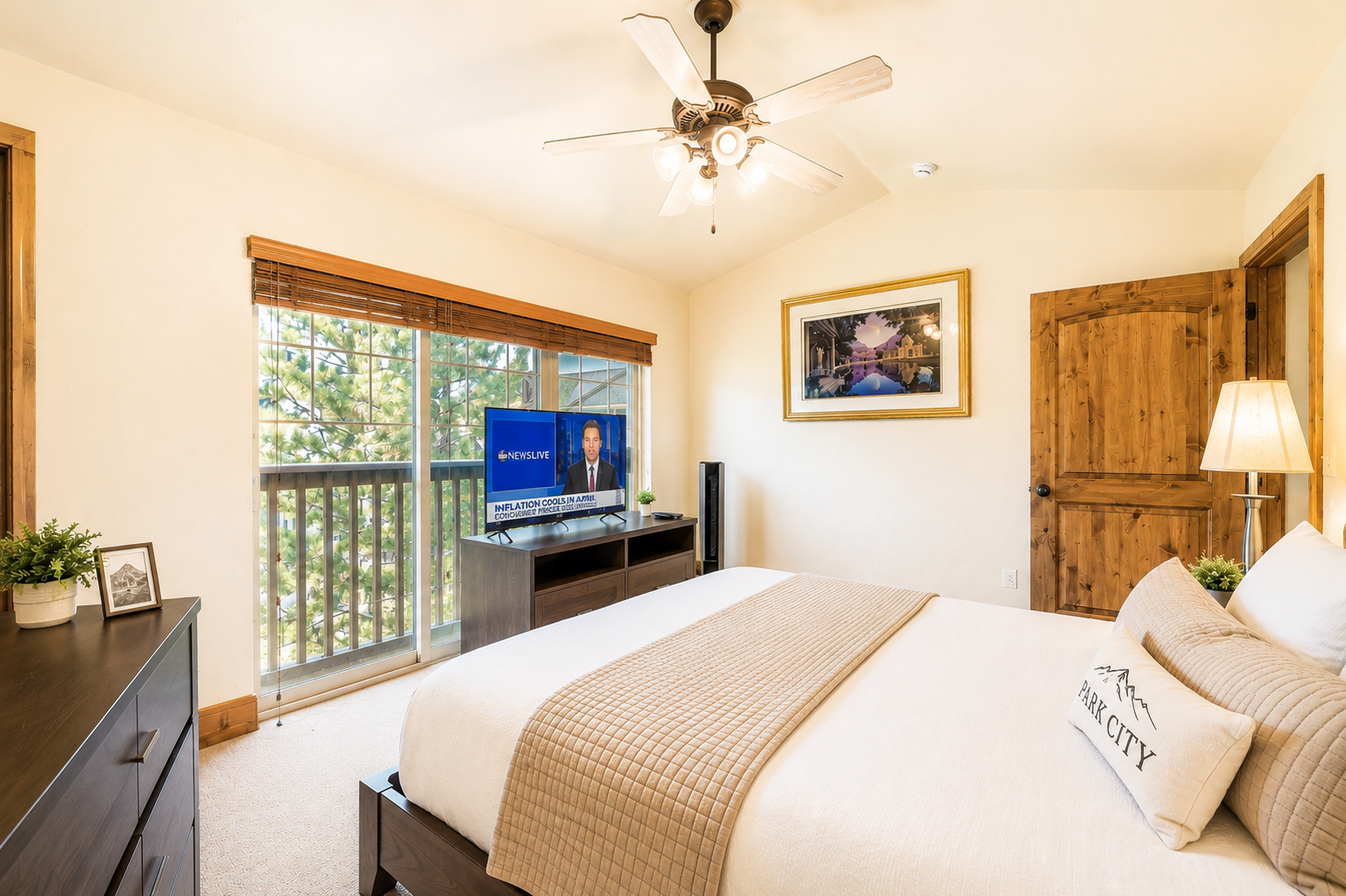 Sink into crisp linens and unwind in your serene bedroom, where warm wood accents and a ceiling fan create a cozy retreat after your mountain adventures.