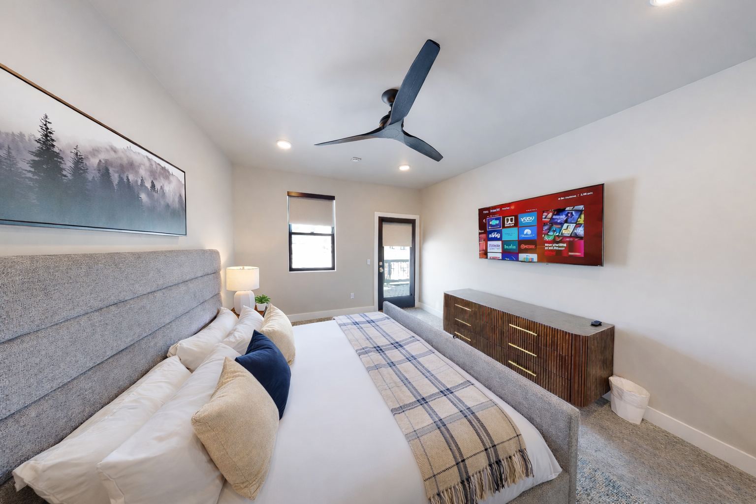 Retreat to this tranquil, modern primary suite featuring a plush king-sized bed with a stylish channeled headboard. Soft, neutral tones and a spacious layout create a serene sanctuary for your ultimate relaxation.