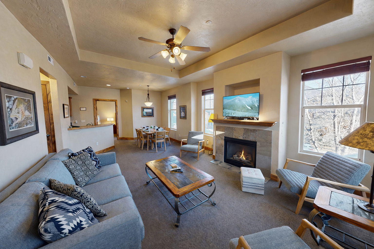 Cozy up by your fireplace while enjoying mountain views through large windows in this inviting living space.
