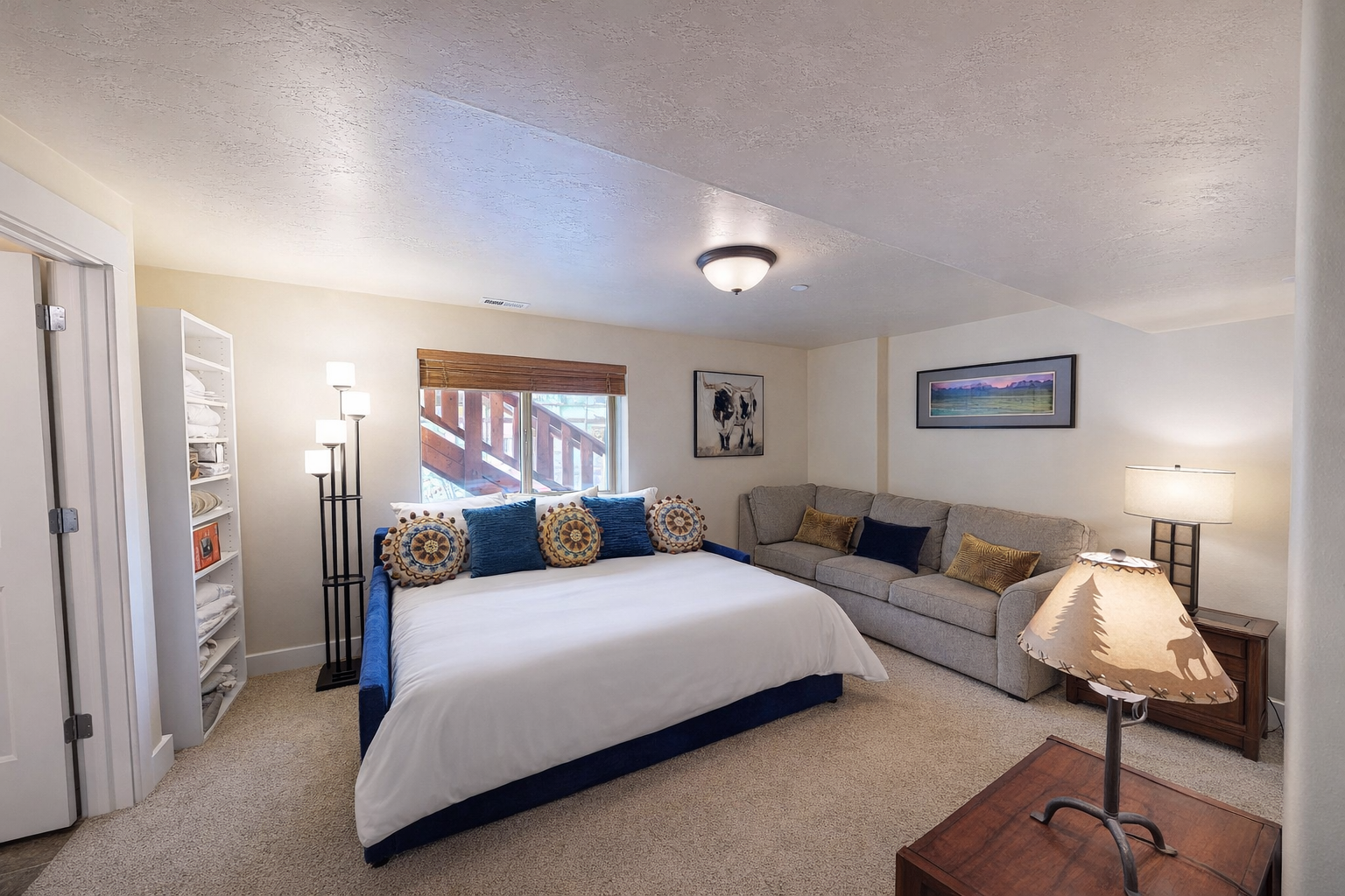 Unwind in your spacious retreat featuring a plush navy bed and cozy gray sofa, perfect for relaxing after exploring the area.