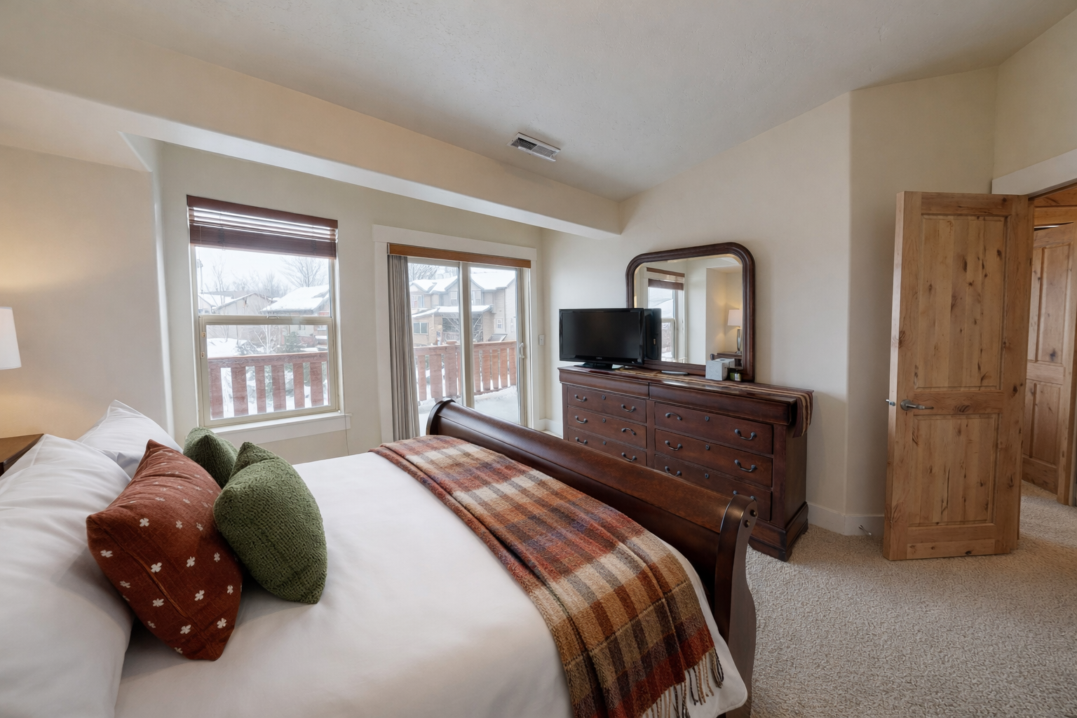 Unwind in your cozy bedroom with mountain views, plaid accents, and rustic wood furnishings that create the perfect alpine retreat.