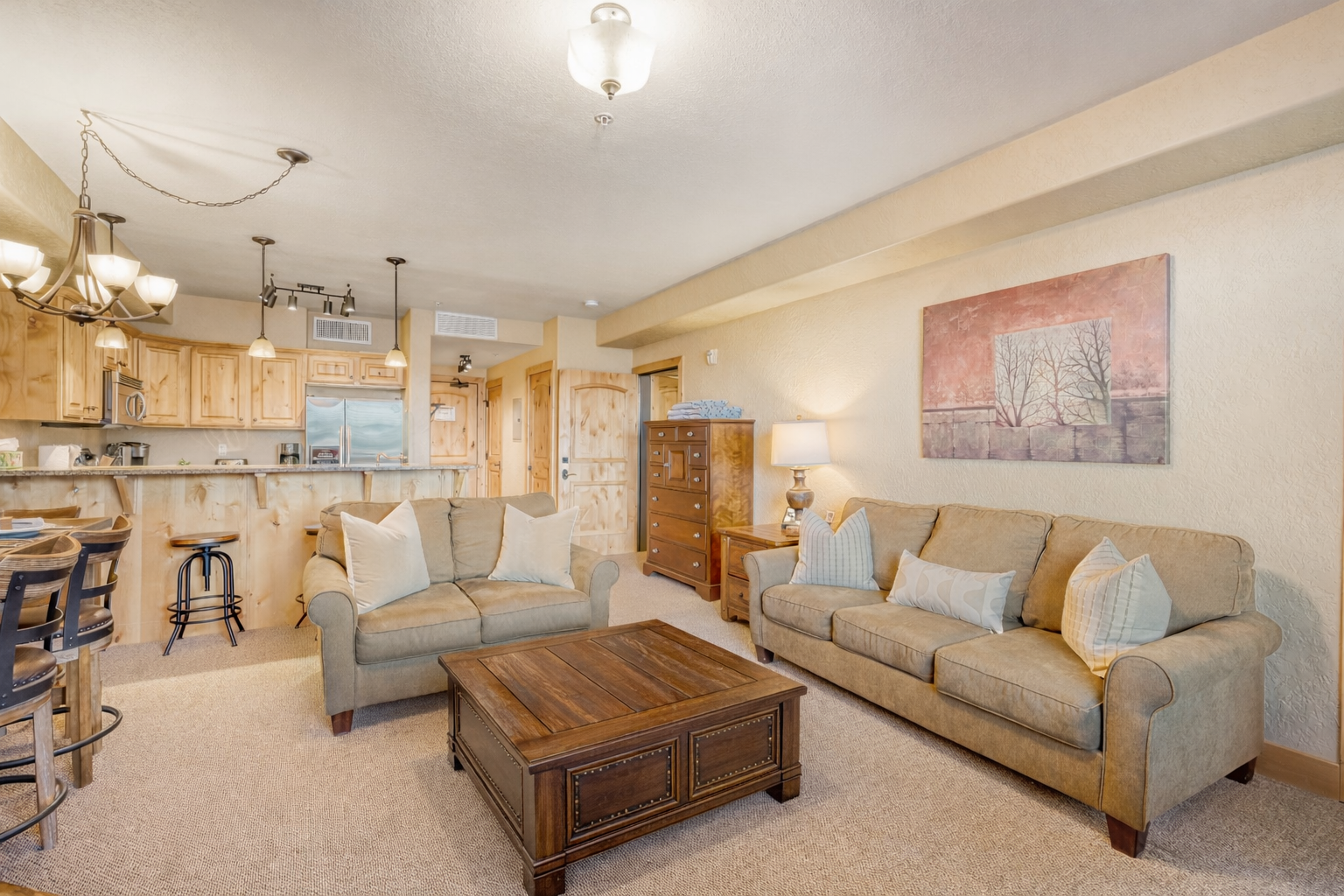 Unwind in your spacious living area where warm wood accents and cozy seating create the perfect atmosphere for relaxation after mountain adventures.
