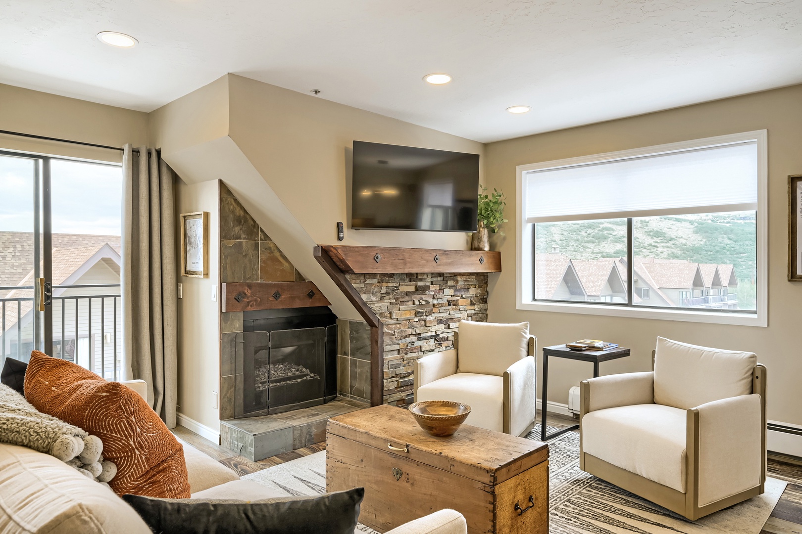 Unwind in your spacious living area, where a stone fireplace and mountain-view windows create the perfect retreat after a day of adventure.