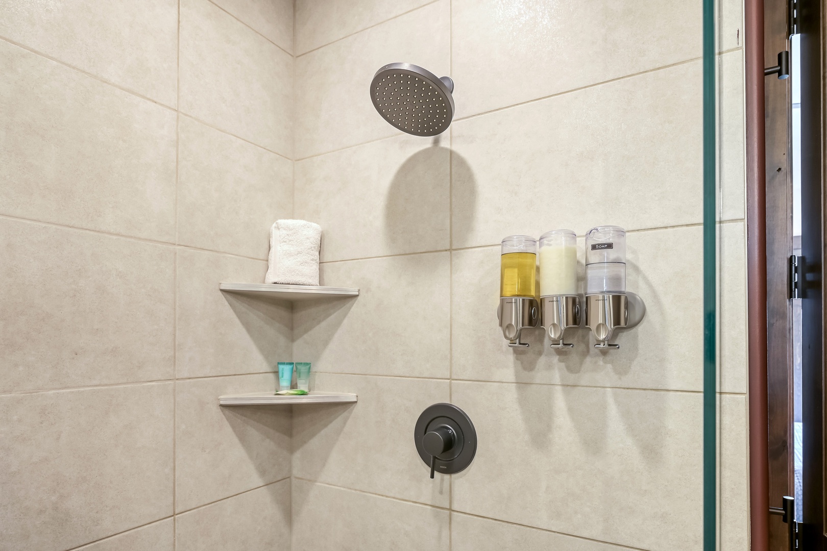 Step into your private shower with a rainfall head, built-in corner shelves for your essentials, and luxe toiletries waiting—everything you need for a refreshing escape.