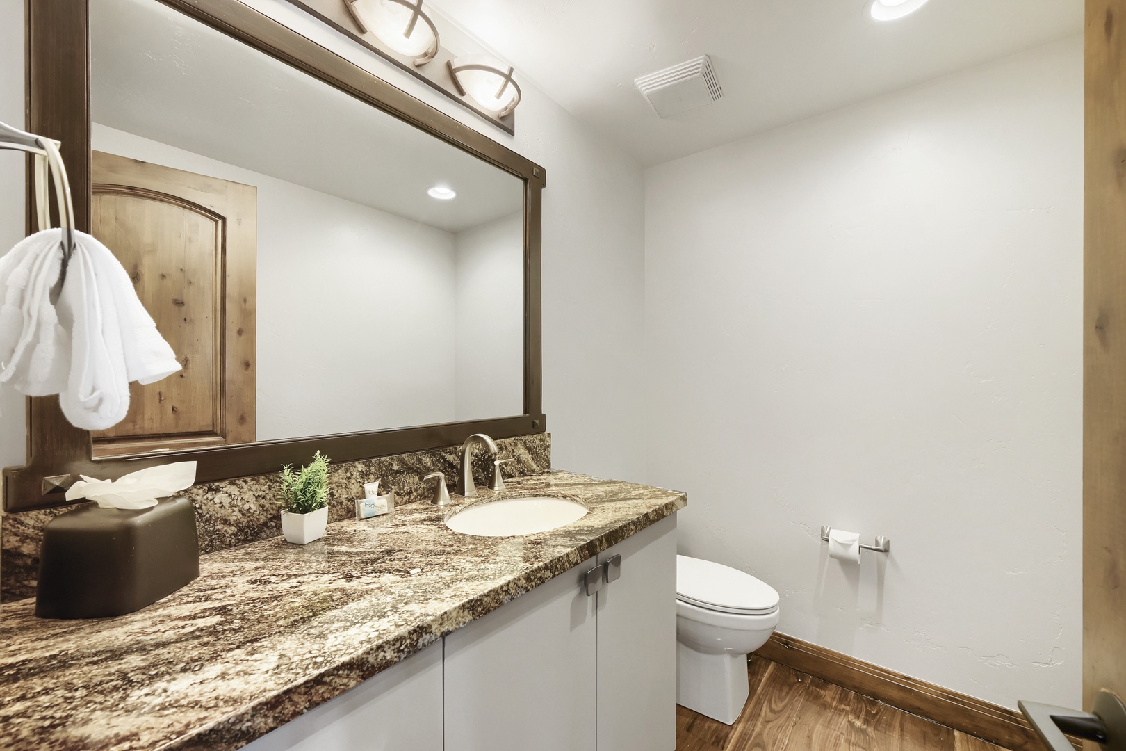 Freshen up in your private bathroom with granite countertops, warm wood accents, and plush white towels waiting for you.
