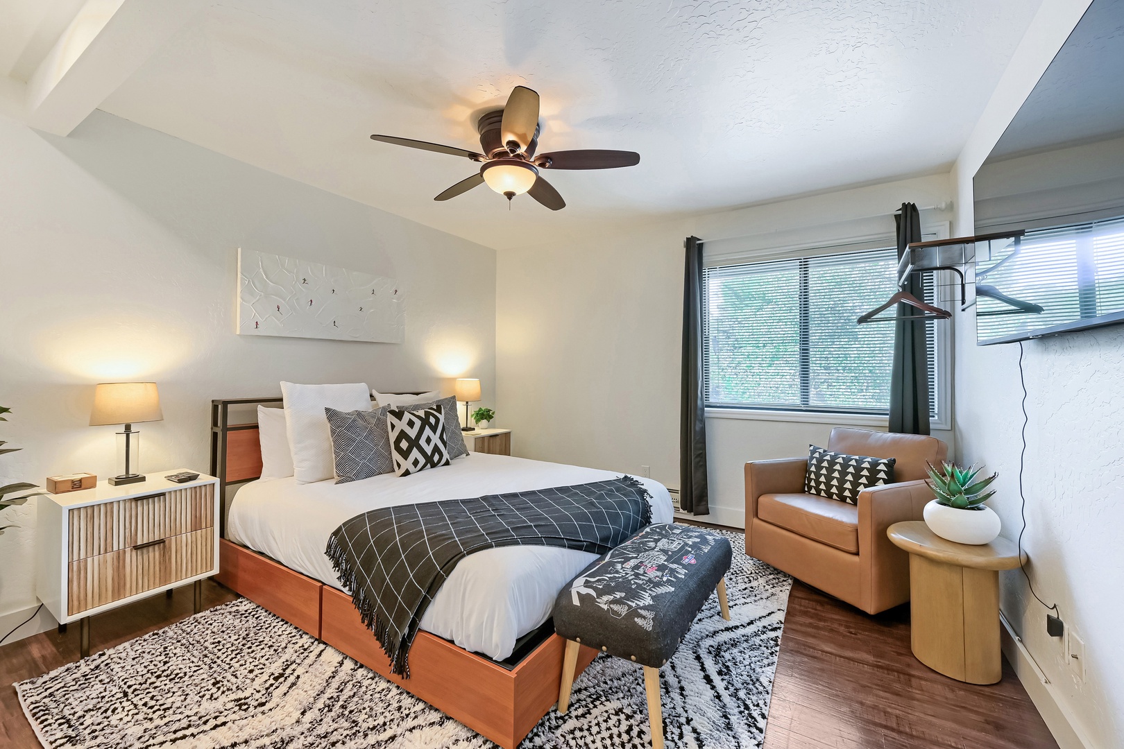 Slip into crisp linens and let the ceiling fan's gentle breeze lull you into a peaceful night's sleep. The modern bedroom offers plenty of storage and a cozy armchair by the window for your morning coffee.