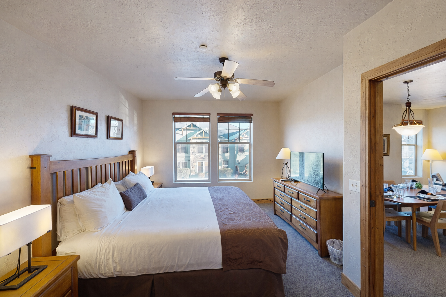 Unwind in your spacious bedroom with crisp linens, warm wood accents, and a ceiling fan to keep you comfortable year-round.