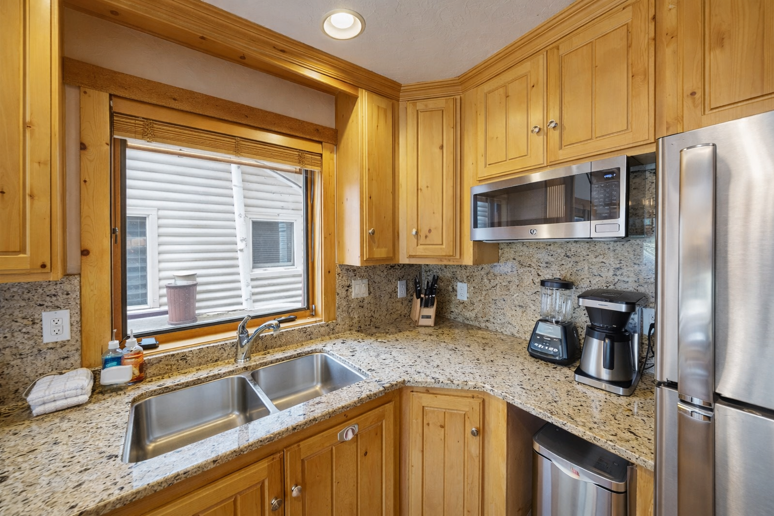 Cook with ease in your fully equipped kitchen featuring granite counters, stainless steel appliances, and warm wood cabinetry for your mountain getaway.