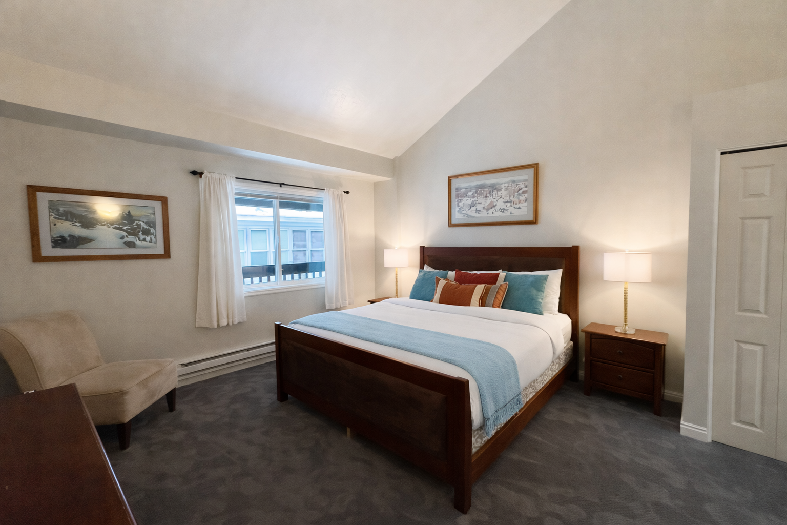 Peaceful guest bedroom featuring a comfortable bed, ceiling fan, and lovely artwork. A tranquil retreat for a restful stay in the mountains.