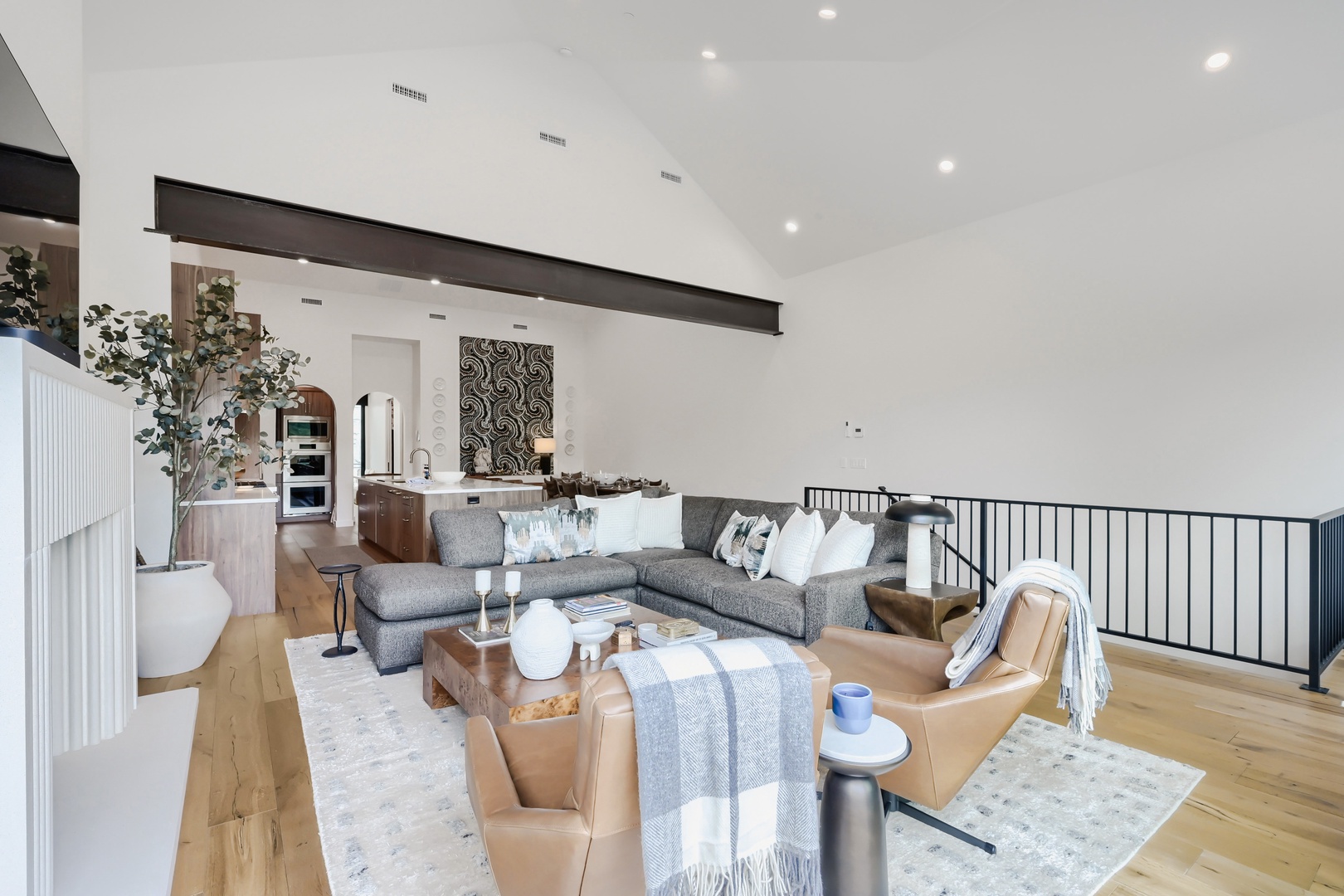 Sink into plush seating in this expansive open-concept living space, where soaring ceilings and natural light create an airy, welcoming atmosphere perfect for your group to gather and relax together.